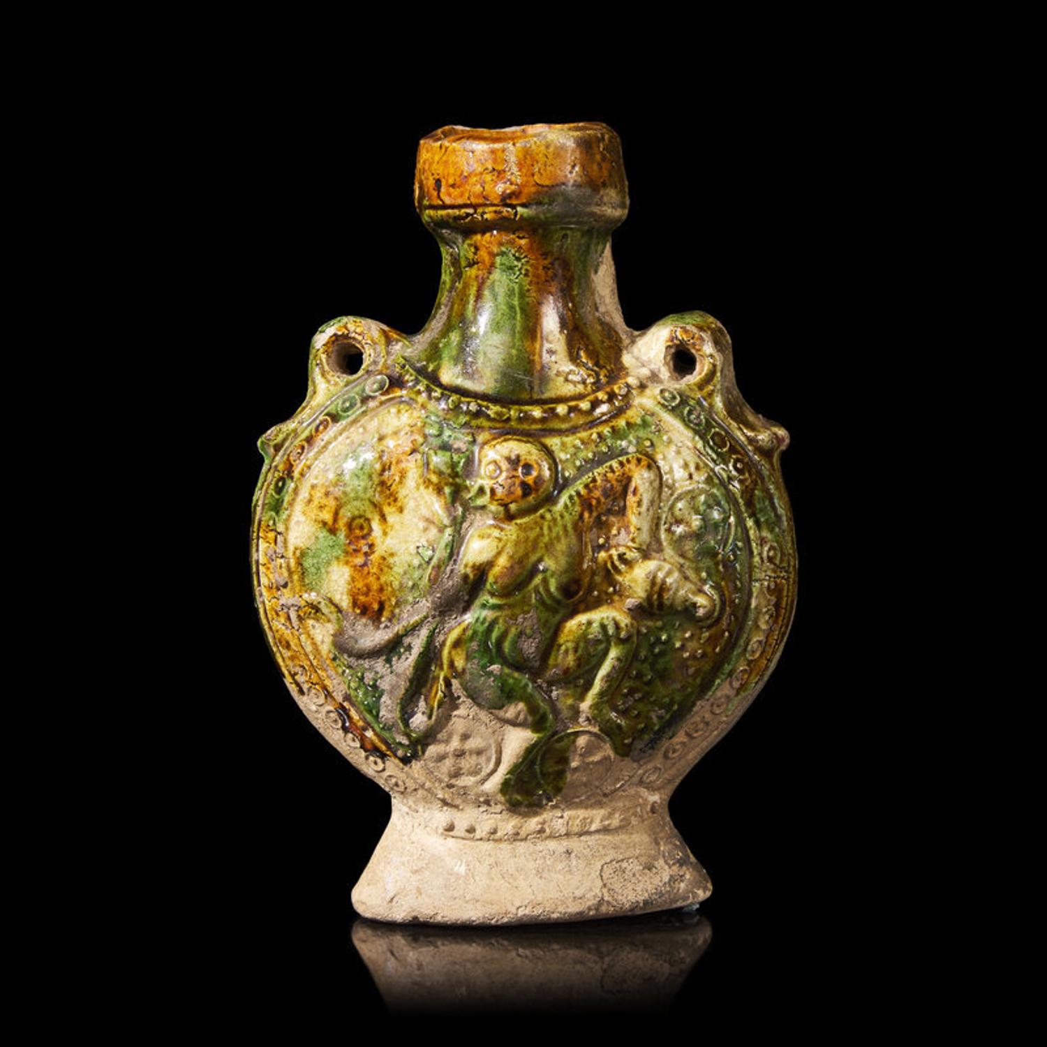 A Chinese Molded Sancai-Glazed Pottery Pilgrim Flask, Tang Dynasty 唐 三彩模印樂舞圖雙繫扁壺