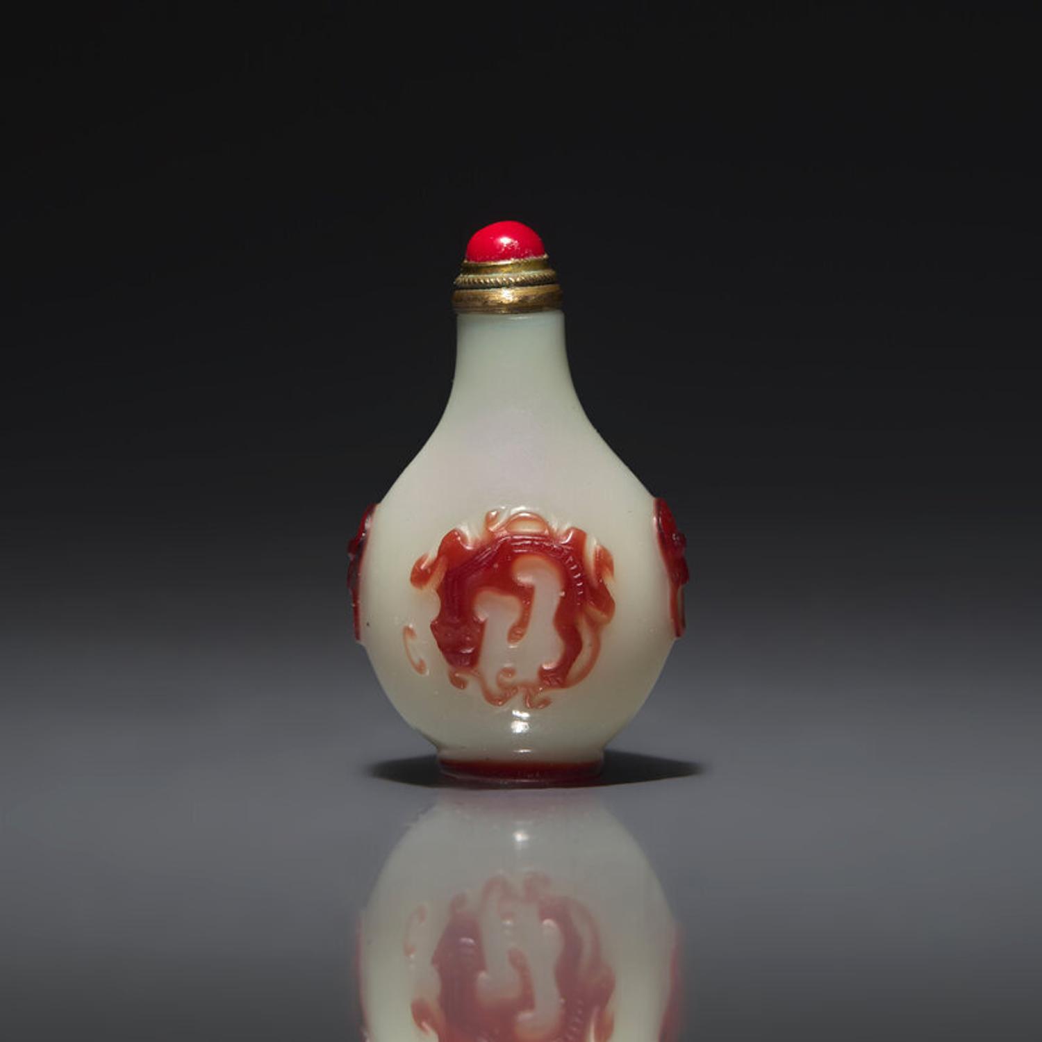 A Chinese Miniature Red-Overlaid Opaline Glass Snuff Bottle, Circa 1750-1820 1750-1820年 涅白地套寶石紅料螭龍紋小鼻烟壺