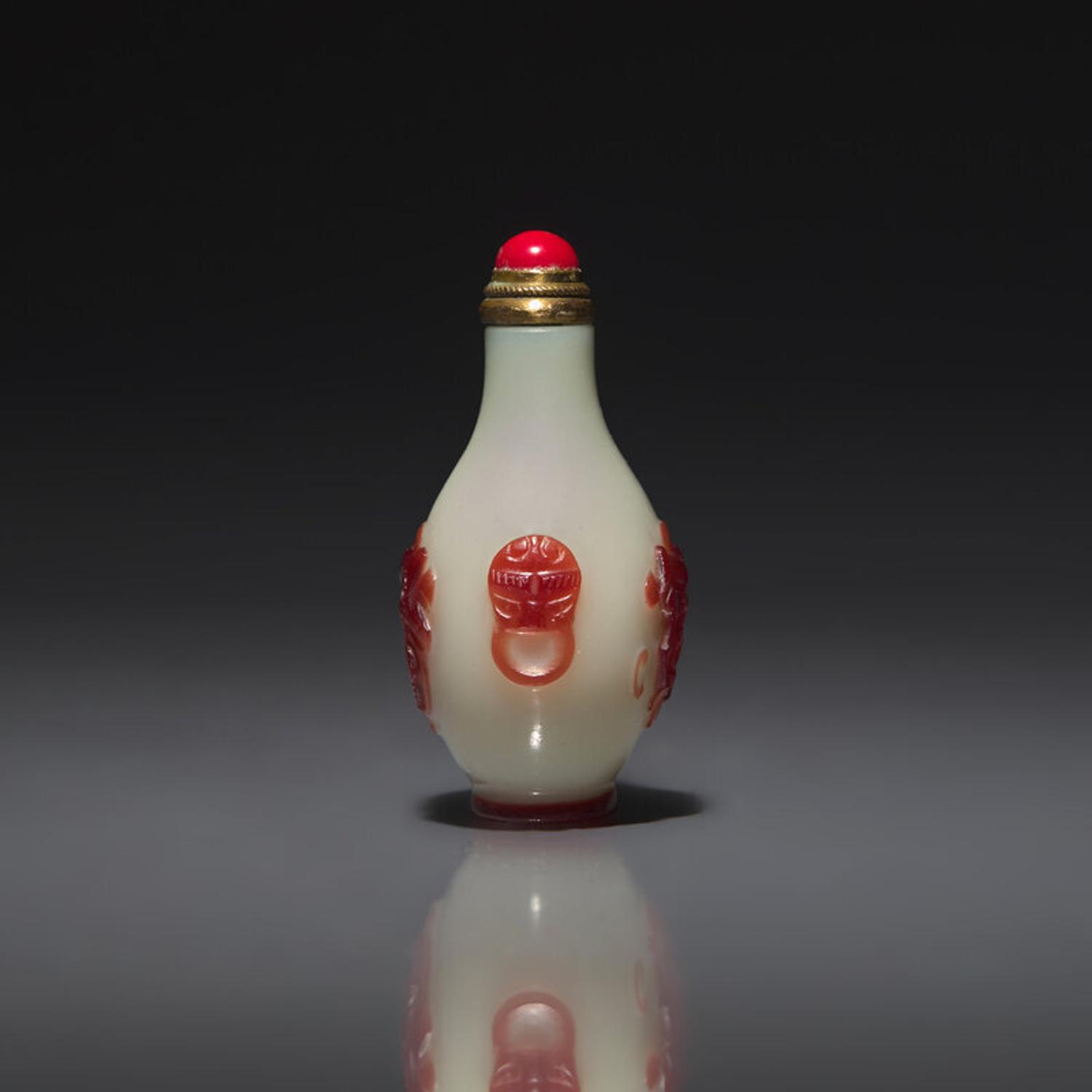 A Chinese Miniature Red-Overlaid Opaline Glass Snuff Bottle, Circa 1750-1820 1750-1820年 涅白地套寶石紅料螭龍紋小鼻烟壺