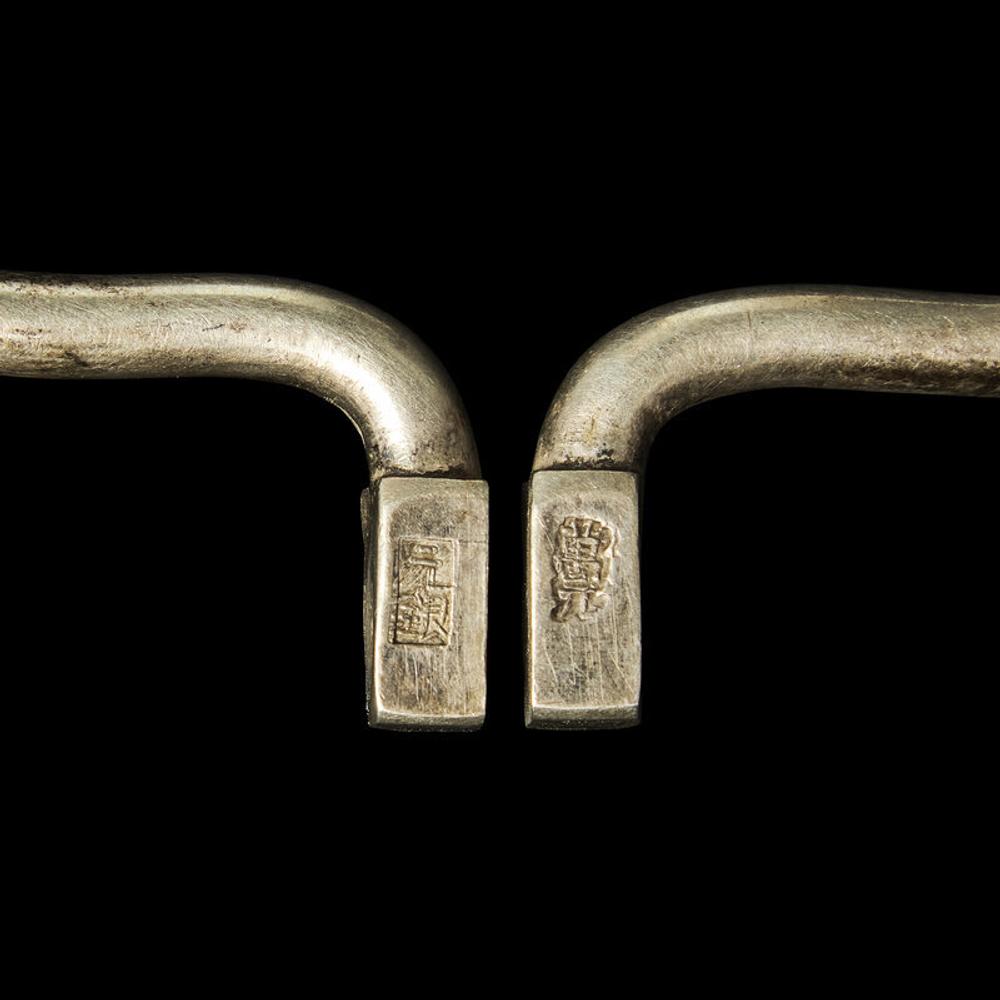 A Chinese Silver Necklace and Eight Chinese Silver Ruyi Lock-Form Pendants, Qing Dynasty 清 銀項圈一及銀如意頭形長命鎖一組八件