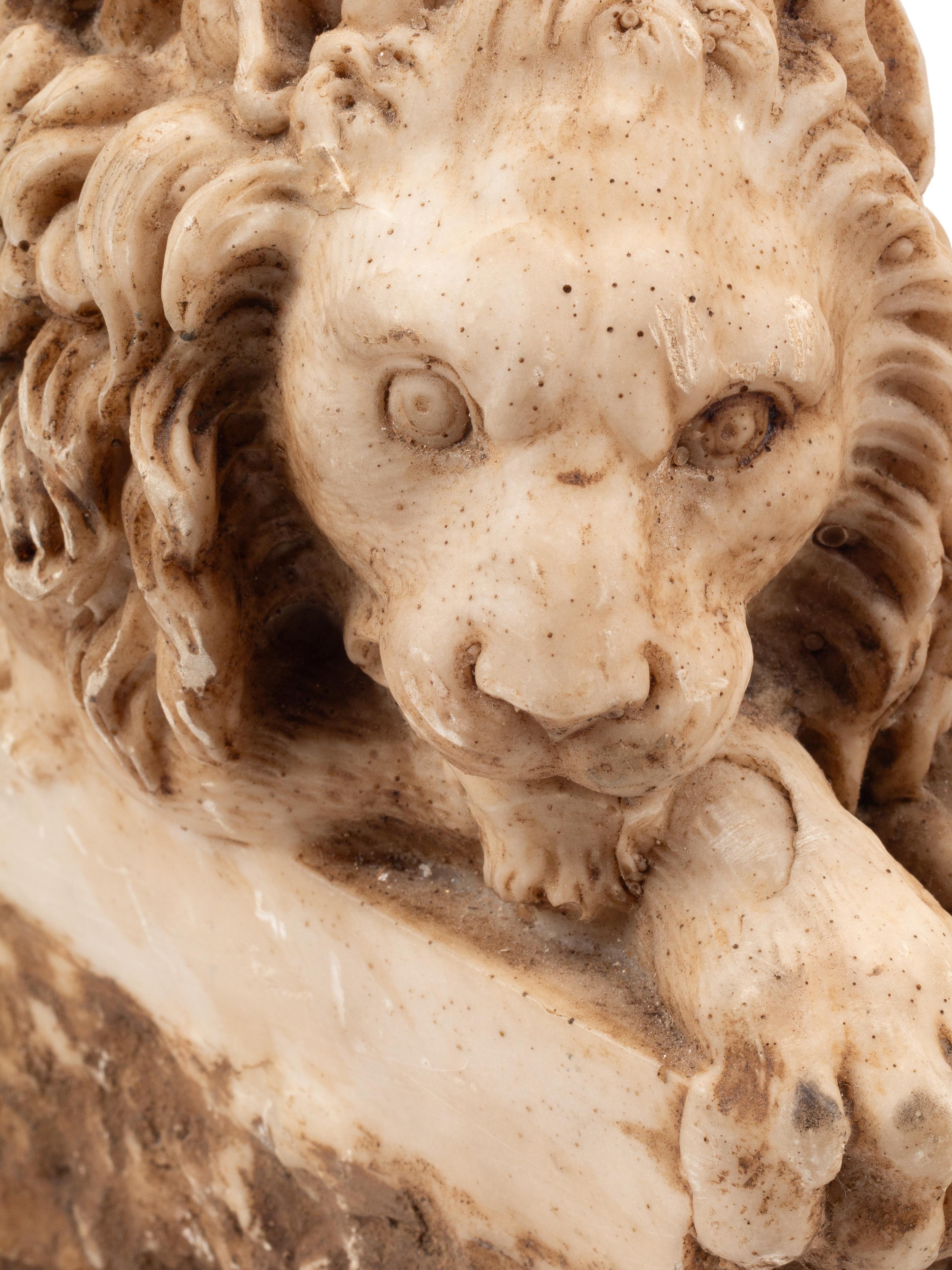A Pair of Composition Marble Recumbent Lions