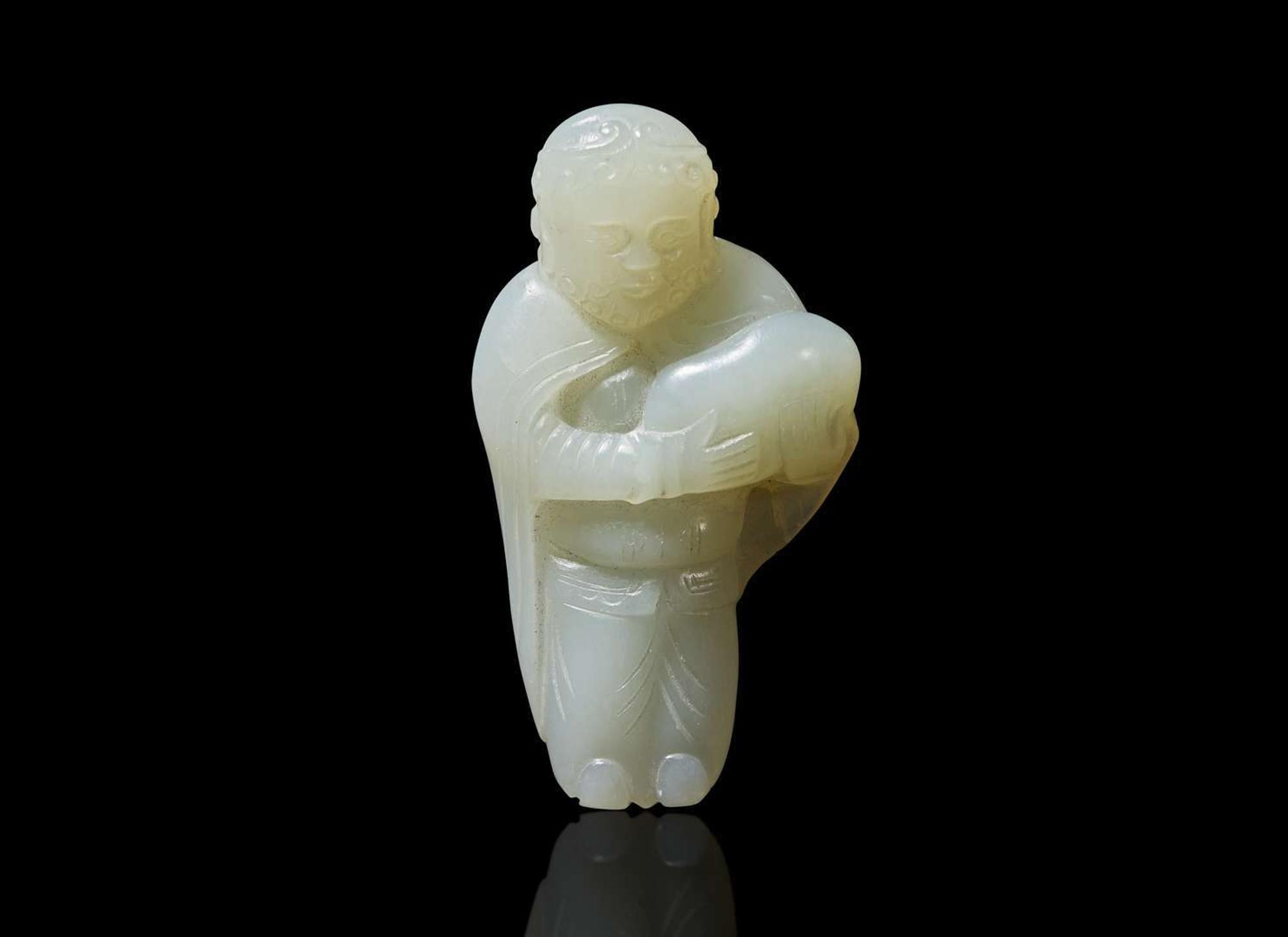A small Chinese carved pale celadon jade figure of a foreigner 青白玉雕胡人