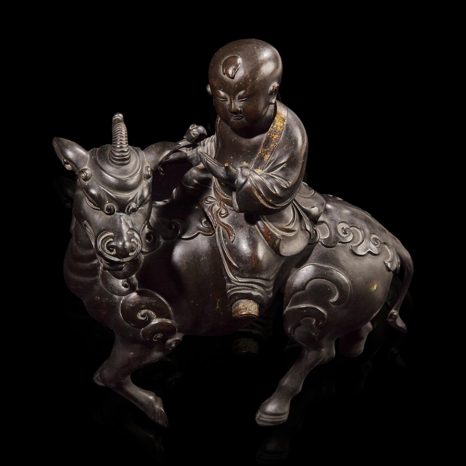 A Chinese Patinated and Parcel-gilt Bronze 'Qilin and Boy' Censer, 17th/18th Century 清早期 銅局部鎏金麒麟童子香薰
