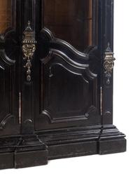 An Italian Rococo Revival Carved Ebonized Bookcase