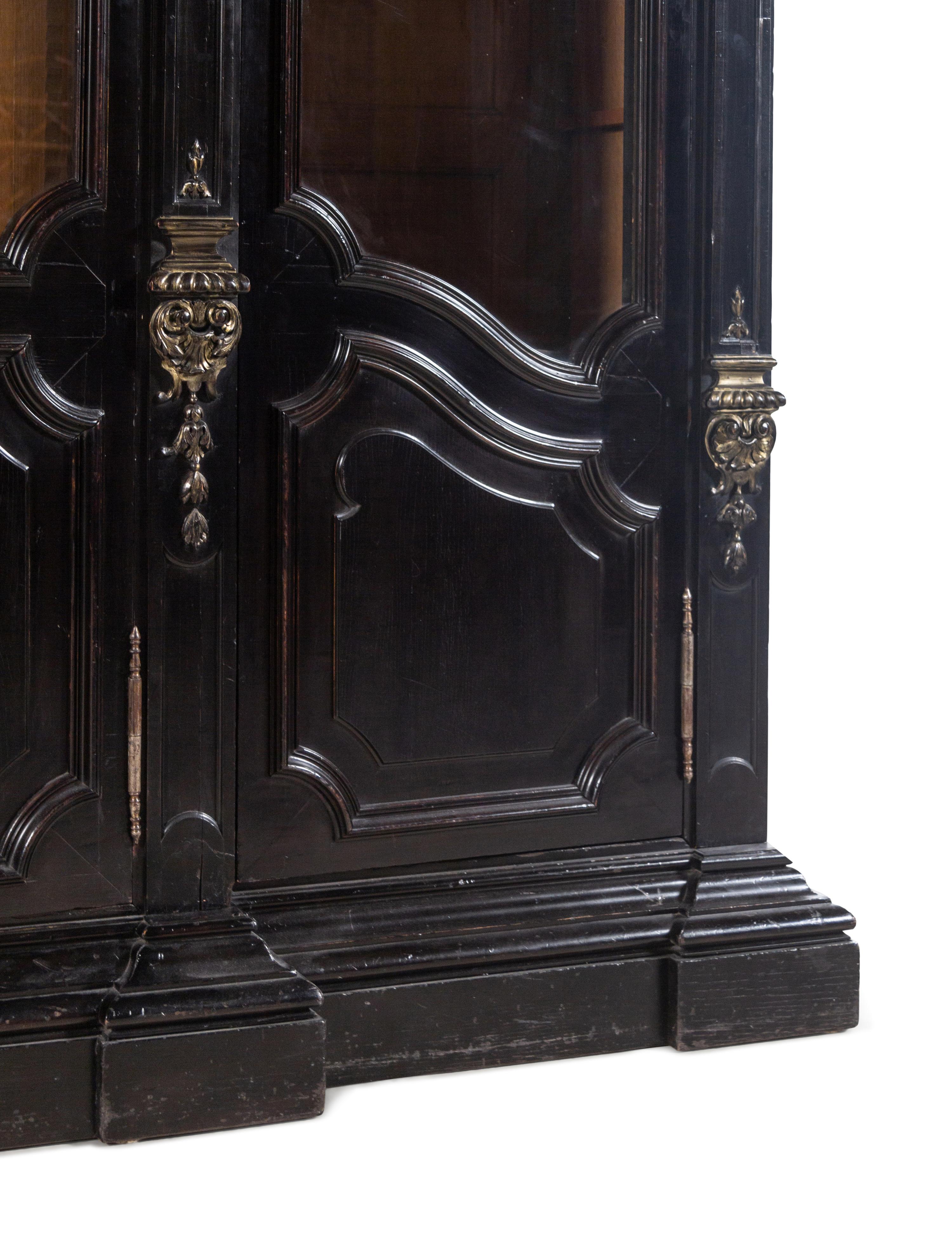 An Italian Rococo Revival Carved Ebonized Bookcase
