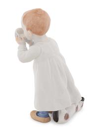 A Meissen Porcelain Figure of a Boy Drinking From a Blue Onion Bowl