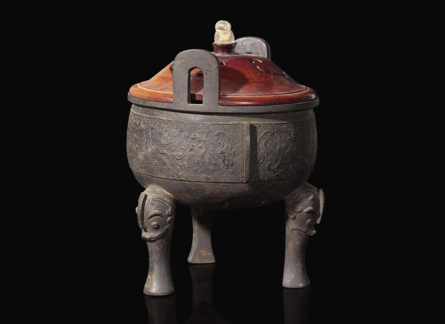 A large Chinese patinated bronze archaistic tripod censer, Ding, and wood cover, The Bronze 17th/18th Century or Earlier 清 青銅鼎式爐