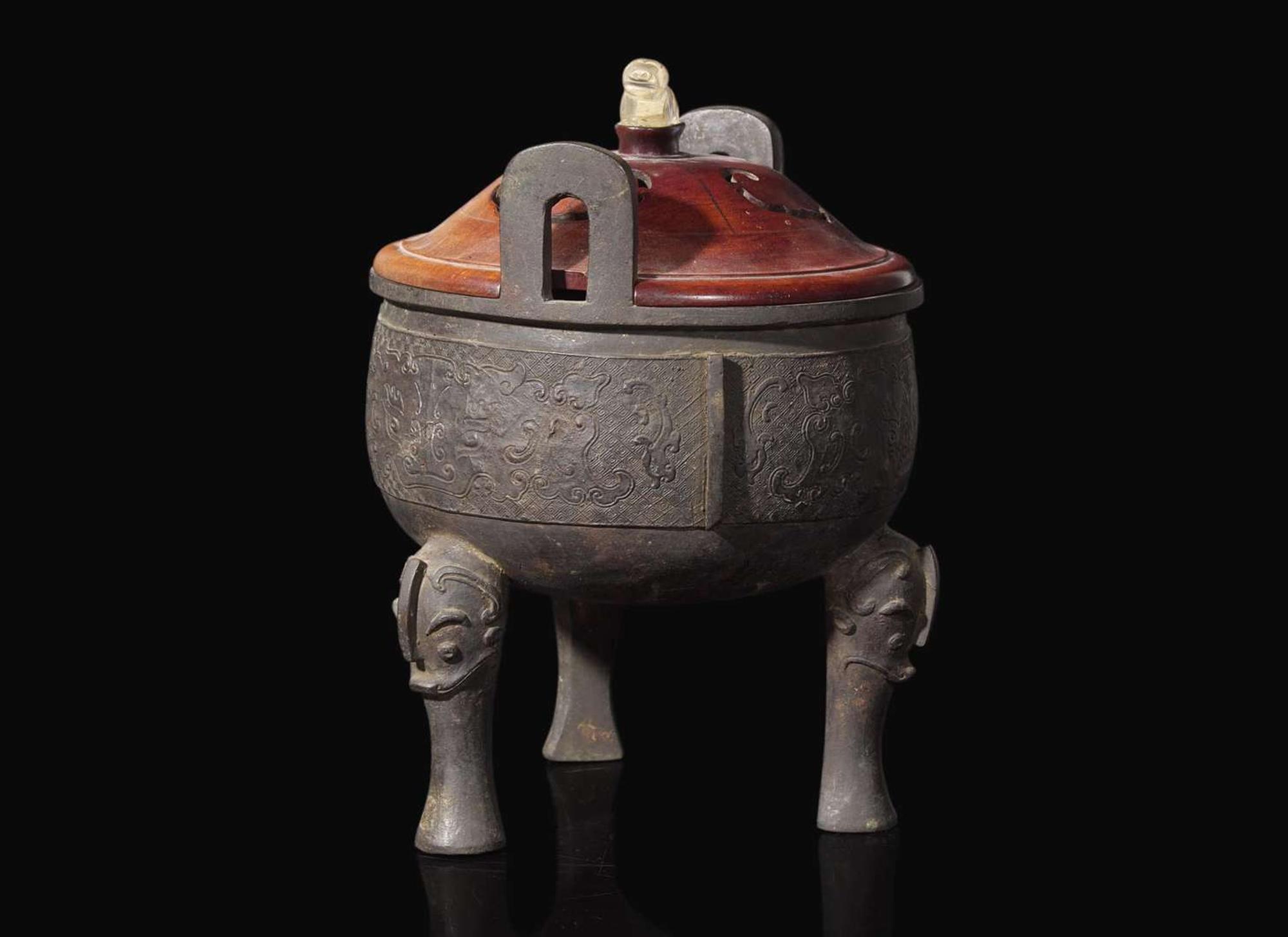 A large Chinese patinated bronze archaistic tripod censer, Ding, and wood cover, The Bronze 17th/18th Century or Earlier 清 青銅鼎式爐
