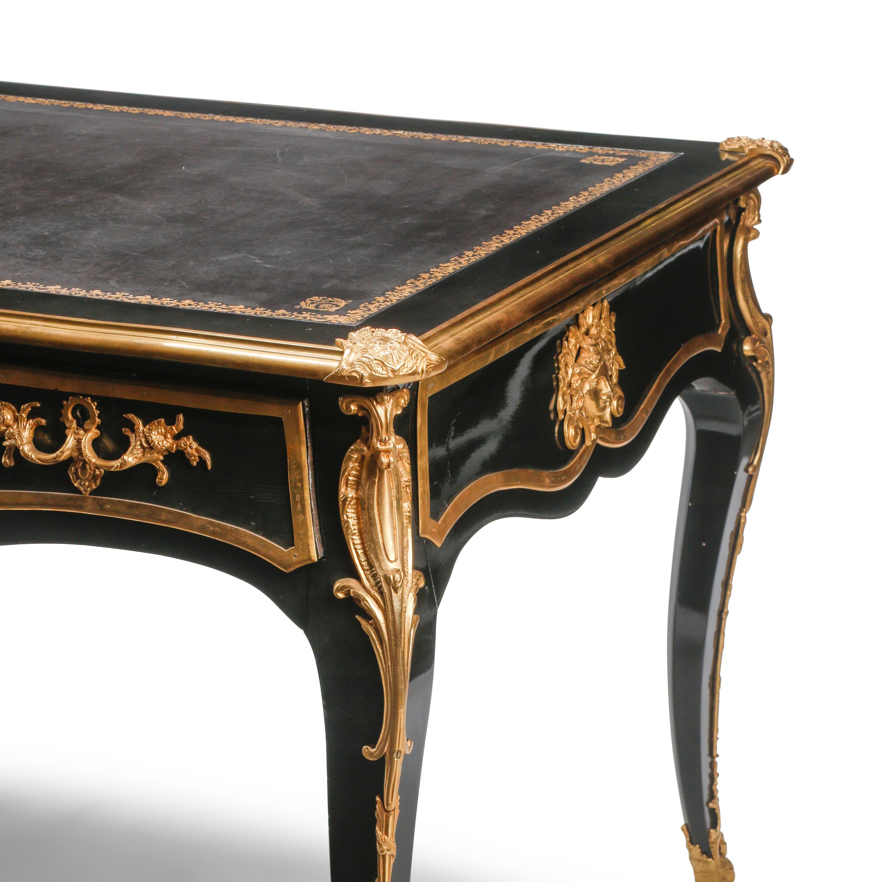 A Louis XV Style Ebonized and Gilt Bronze Mounted Bureau Plat
