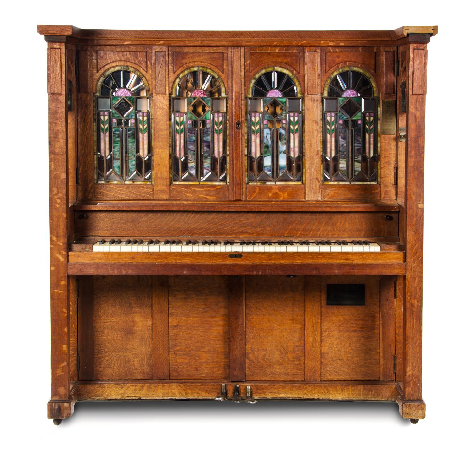A Marquette Cremona Style K Oak and Stained Glass Orchestrion, CIRCA 1915, SERIAL NO. 11527, Height 66 x width 64 1/2 x depth 31 1/4 in — CIRCA 1915, SERIAL NO. 11527,