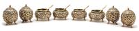 A Group of Eight Repousse Gilt Metal Salts, , comprising four footed open salts with spoons and four globe form footed shakers.