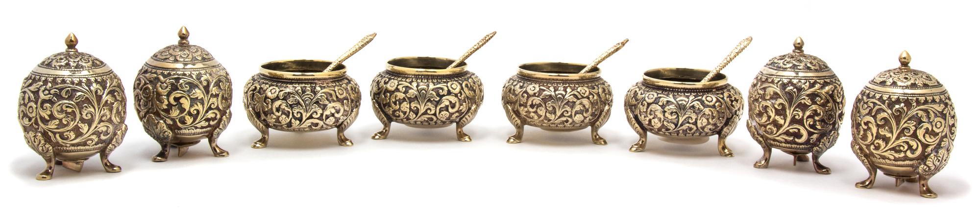 A Group of Eight Repousse Gilt Metal Salts, , comprising four footed open salts with spoons and four globe form footed shakers.