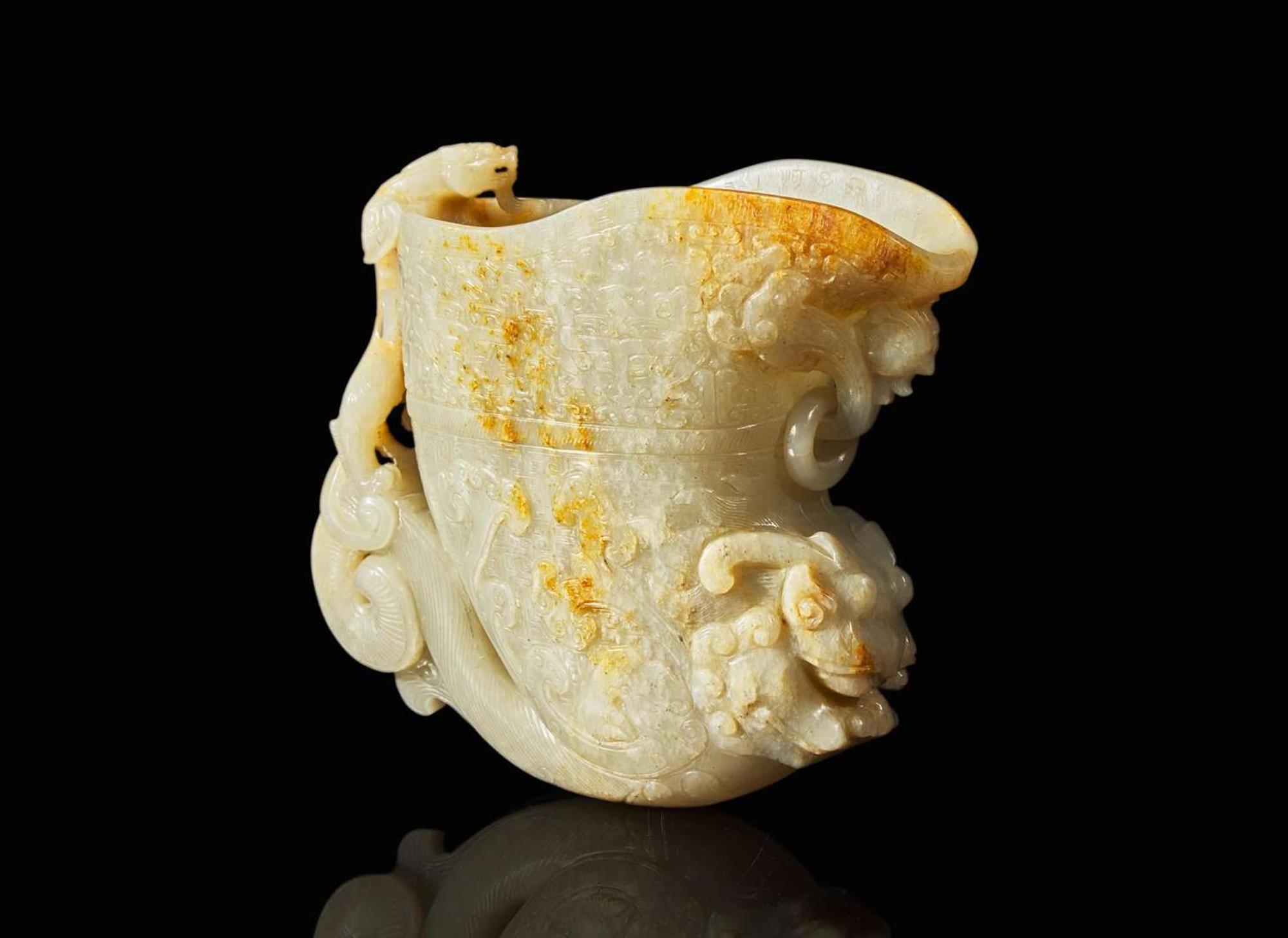 A large Chinese carved pale celadon and russet jade rhyton vessel 青白玉雕觥杯