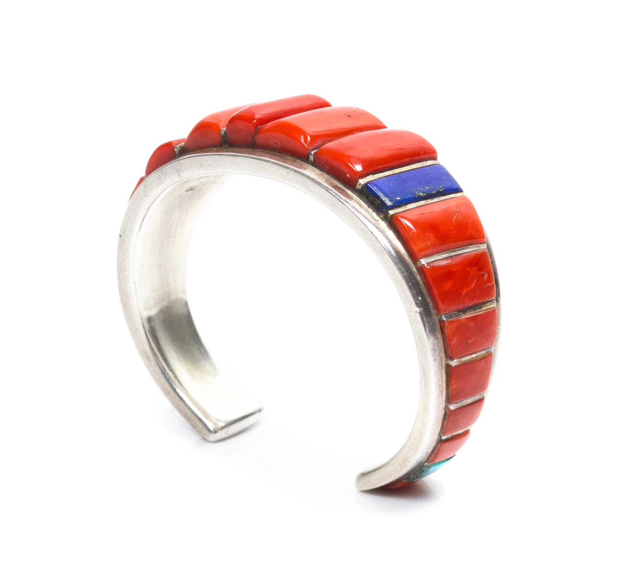 A Zuni Silver, Coral and Multi-Gem Bracelet, Roger Tsabetsaye Length 4 7/8 x opening 1 x width 3/4 inches.