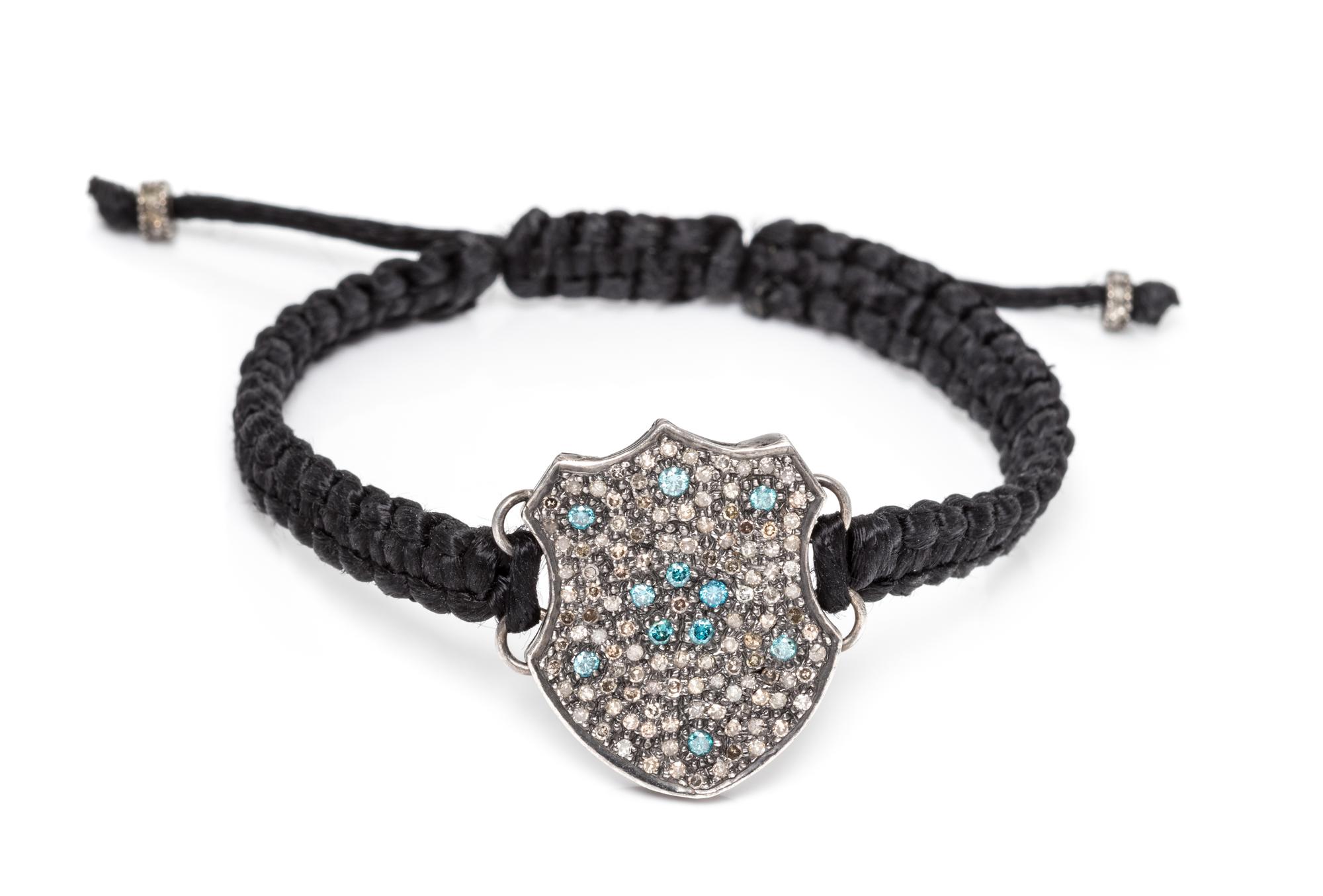 A Silver, Diamond and Treated Diamond Cord Bracelet, 5.80 dwts.