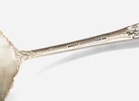 An assembled group of nine sterling silver floral repousse serving utensils, various makers, including Bailey Banks & Biddle Co. and J.E. Caldwell & Co., Philadelphia, PA, and The James R. Armiger Co., Baltimore, MD, and others, late 19th / early 20th century