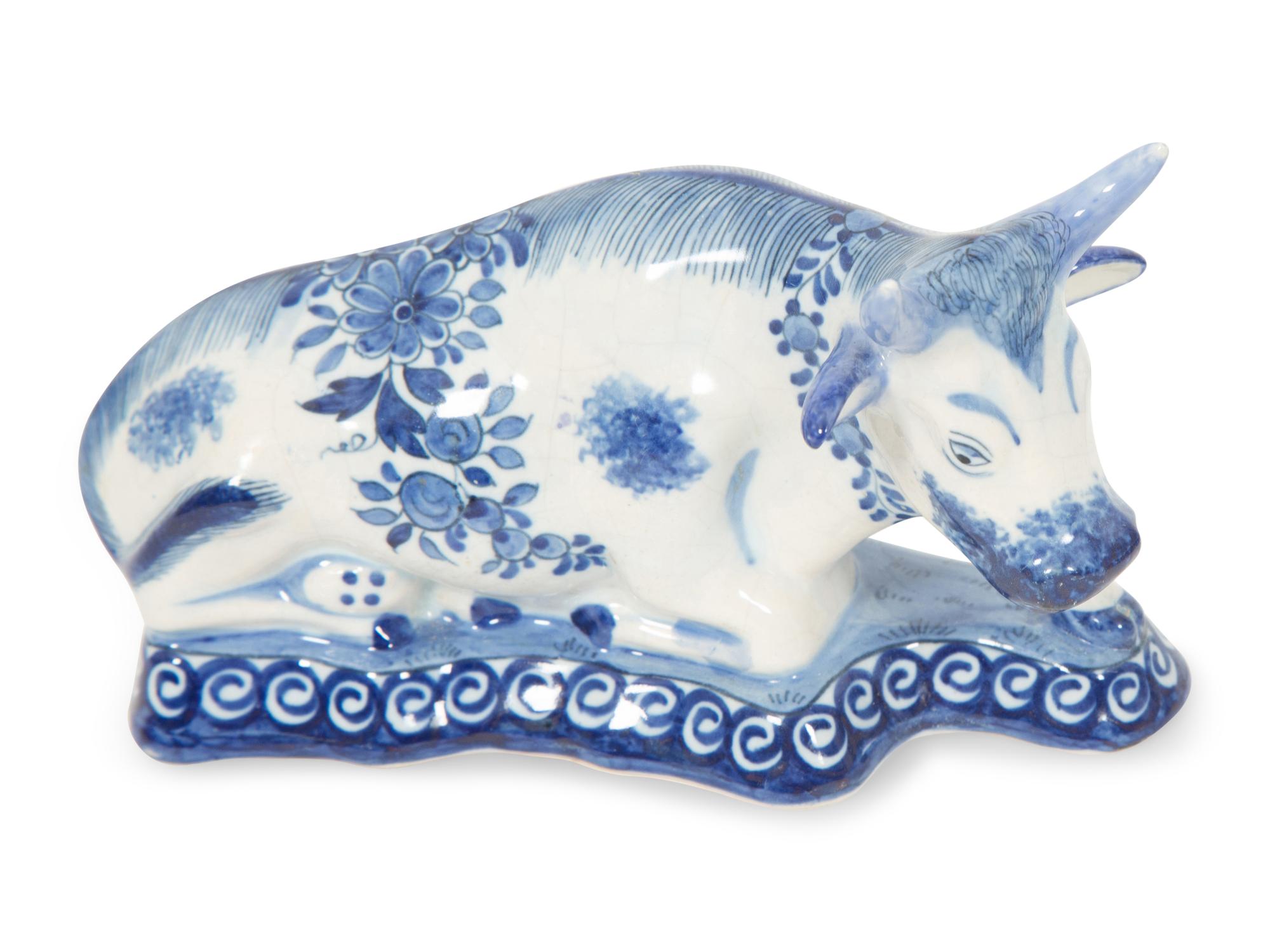 A Delft Blue and White Seated Dog and a Recumbent Cow
