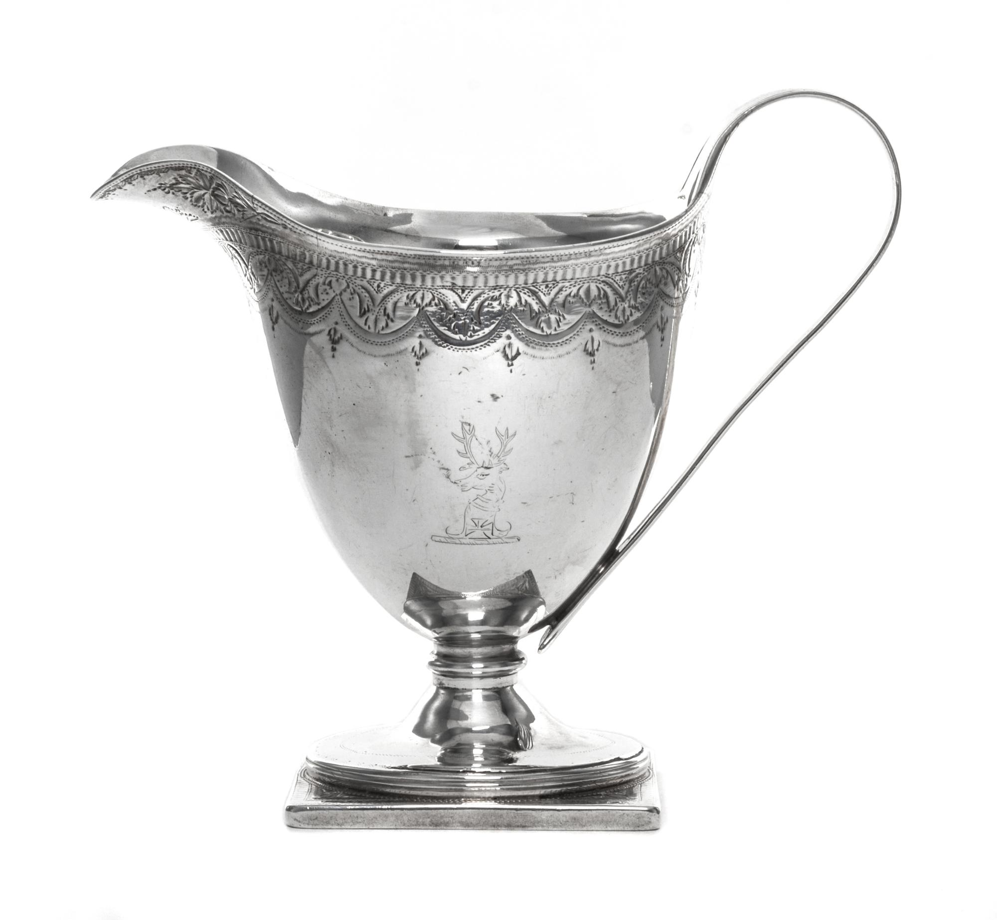 A George III Silver Creamer, John Schofield, London, 1790, having a bright cut foliate swag border at the upper rim, one side engraved