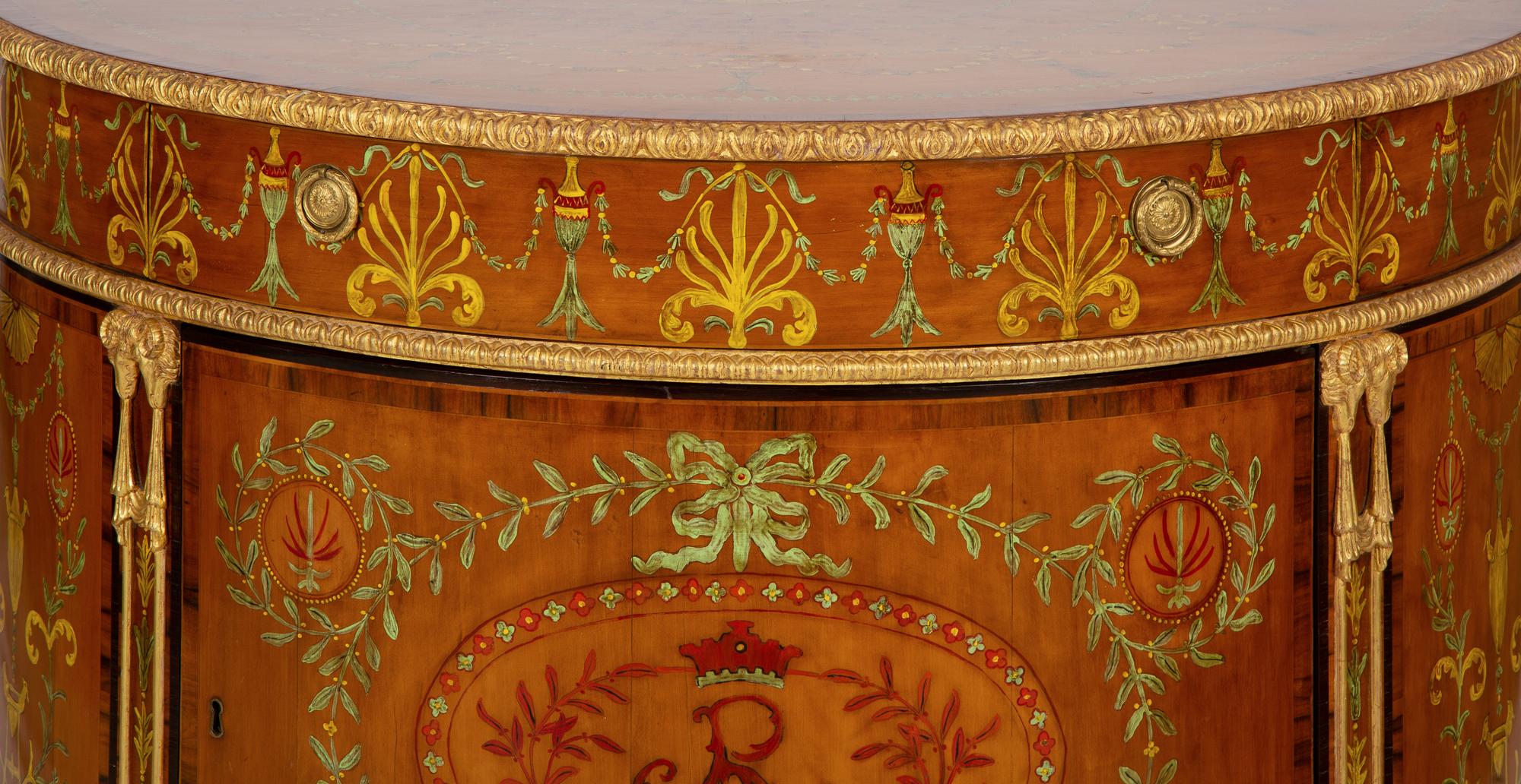A Pair of Adam Style Painted Parcel Gilt and Marquetry Inlaid Demilune Commodes