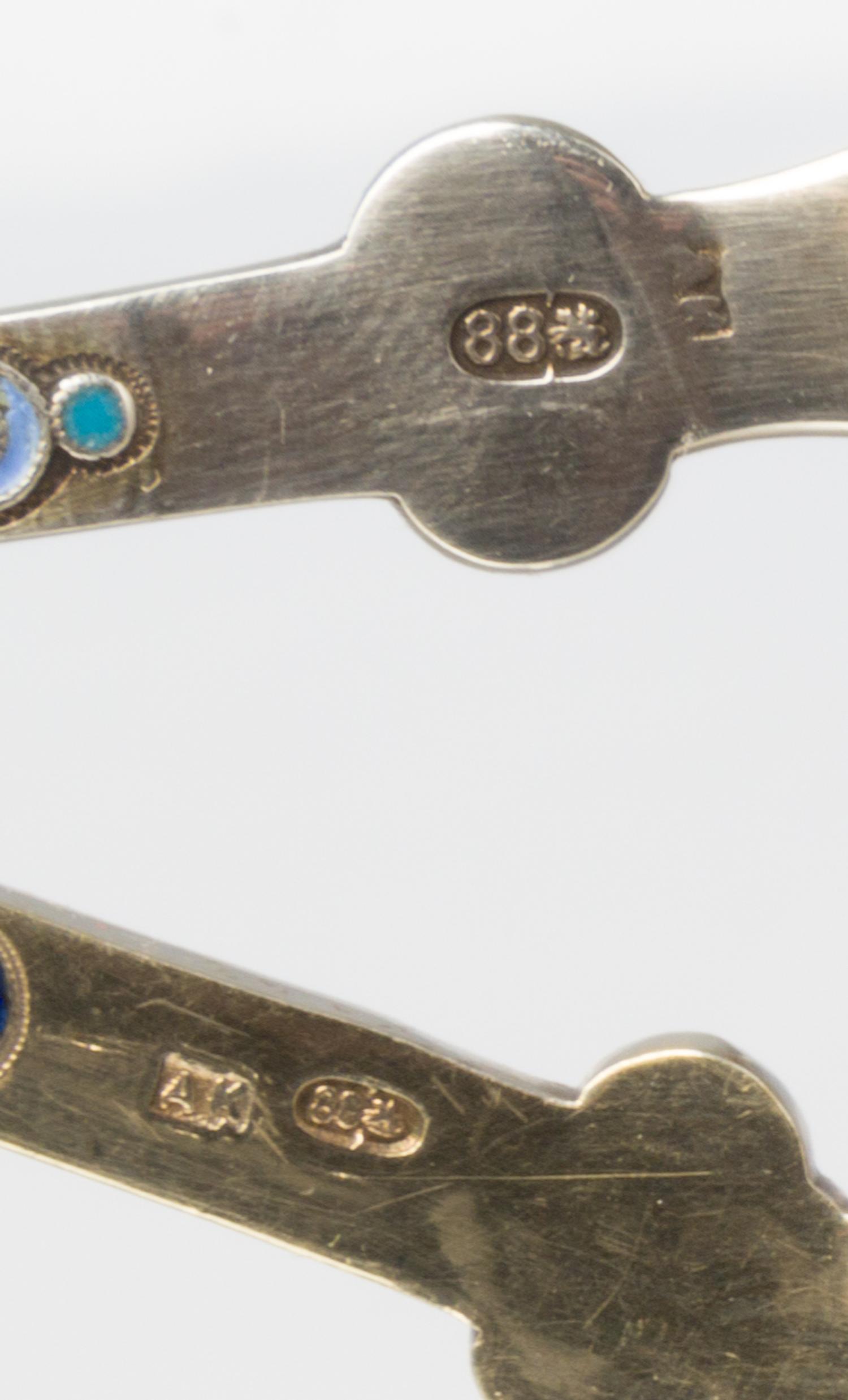 Two Russian Silver-Gilt and Enamel Tea Strainers, Marks likely of Antip Kuzmichev, Moscow, late 19th century, each with a flared handle