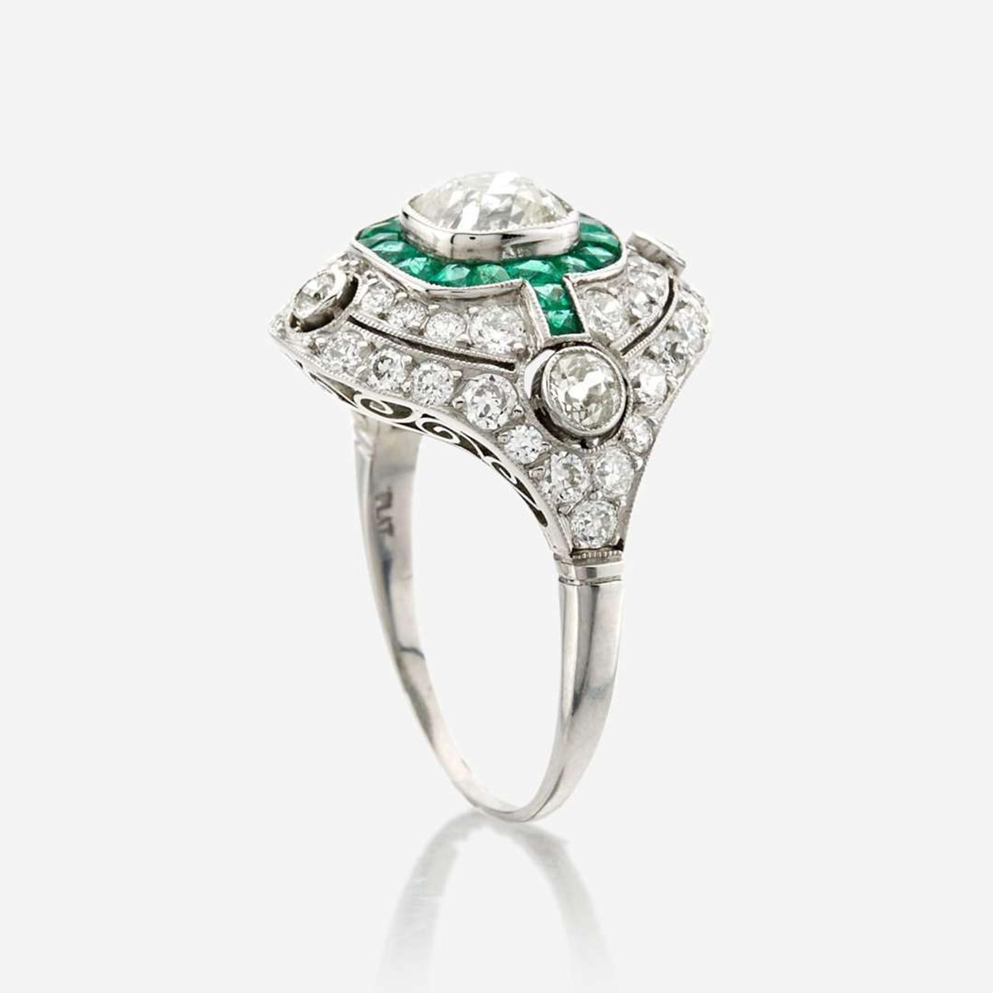 A diamond, emerald, and platinum ring