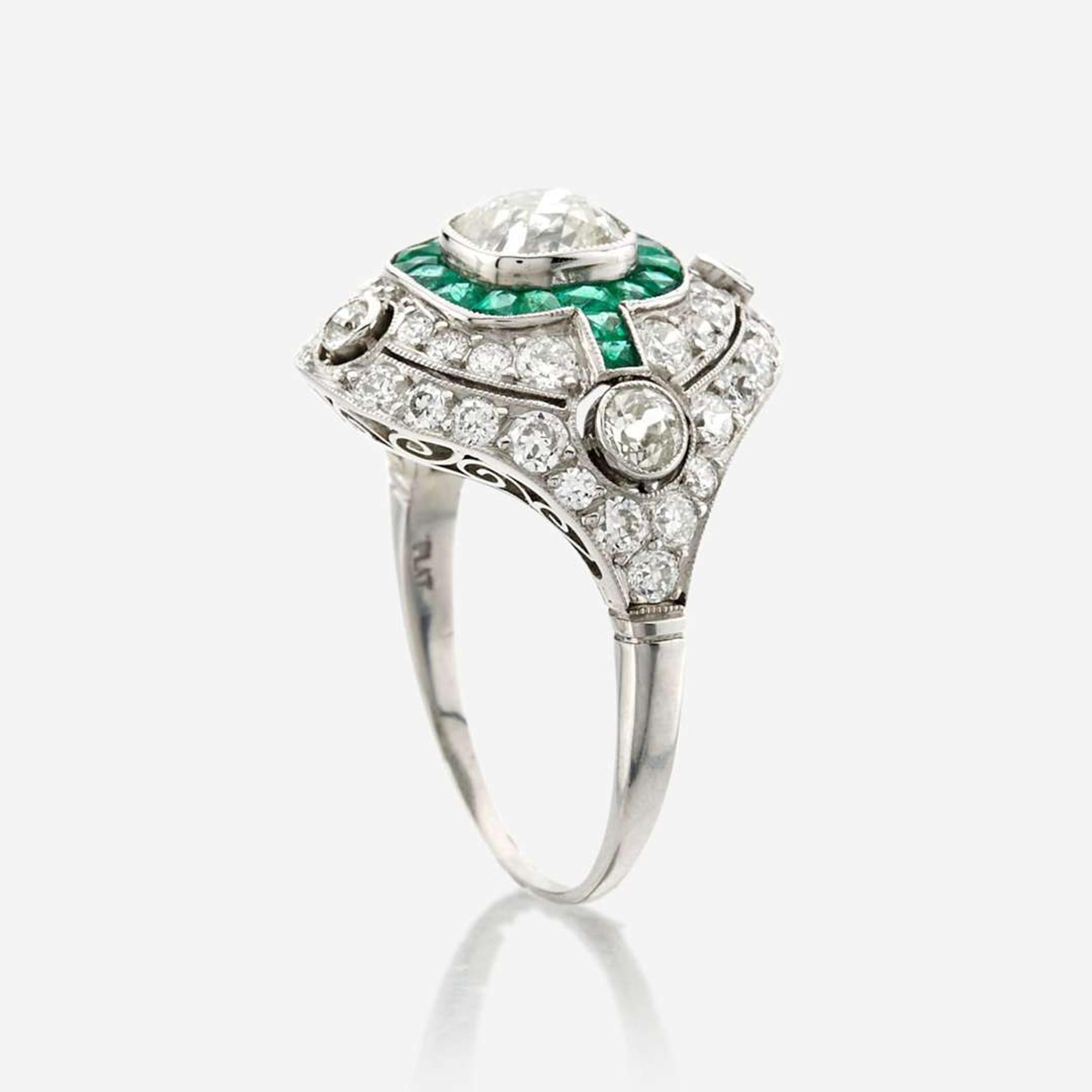 A diamond, emerald, and platinum ring
