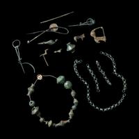 A Group of European and Luristan Bronze Fragmentary Fibulae, Beads, and Chains