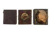 [EARLY PHOTOGRAPHY - PORTRAITURE]. A pair of daguerreotypes featuring a father holding his daughter on his lap, with hand painted and other cases, including: