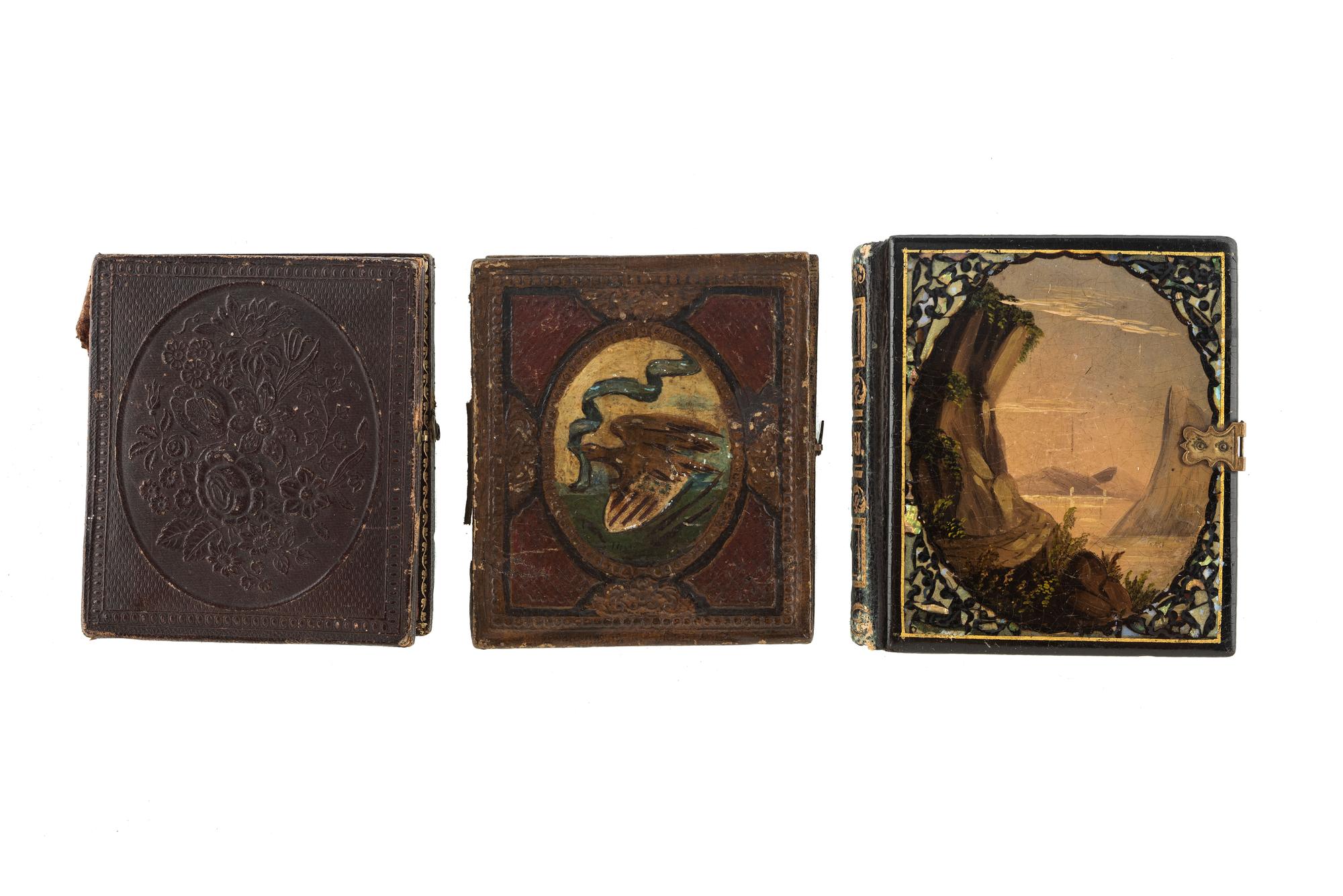 [EARLY PHOTOGRAPHY - PORTRAITURE]. A pair of daguerreotypes featuring a father holding his daughter on his lap, with hand painted and other cases, including: