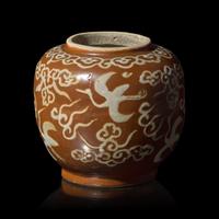 A Chinese White Slip Decorated Persimmon Ground Porcelain Jar, Ming Dynasty, Jiajing/Wanli Period — 明嘉靖/萬曆 紫金釉云鹤纹罐
