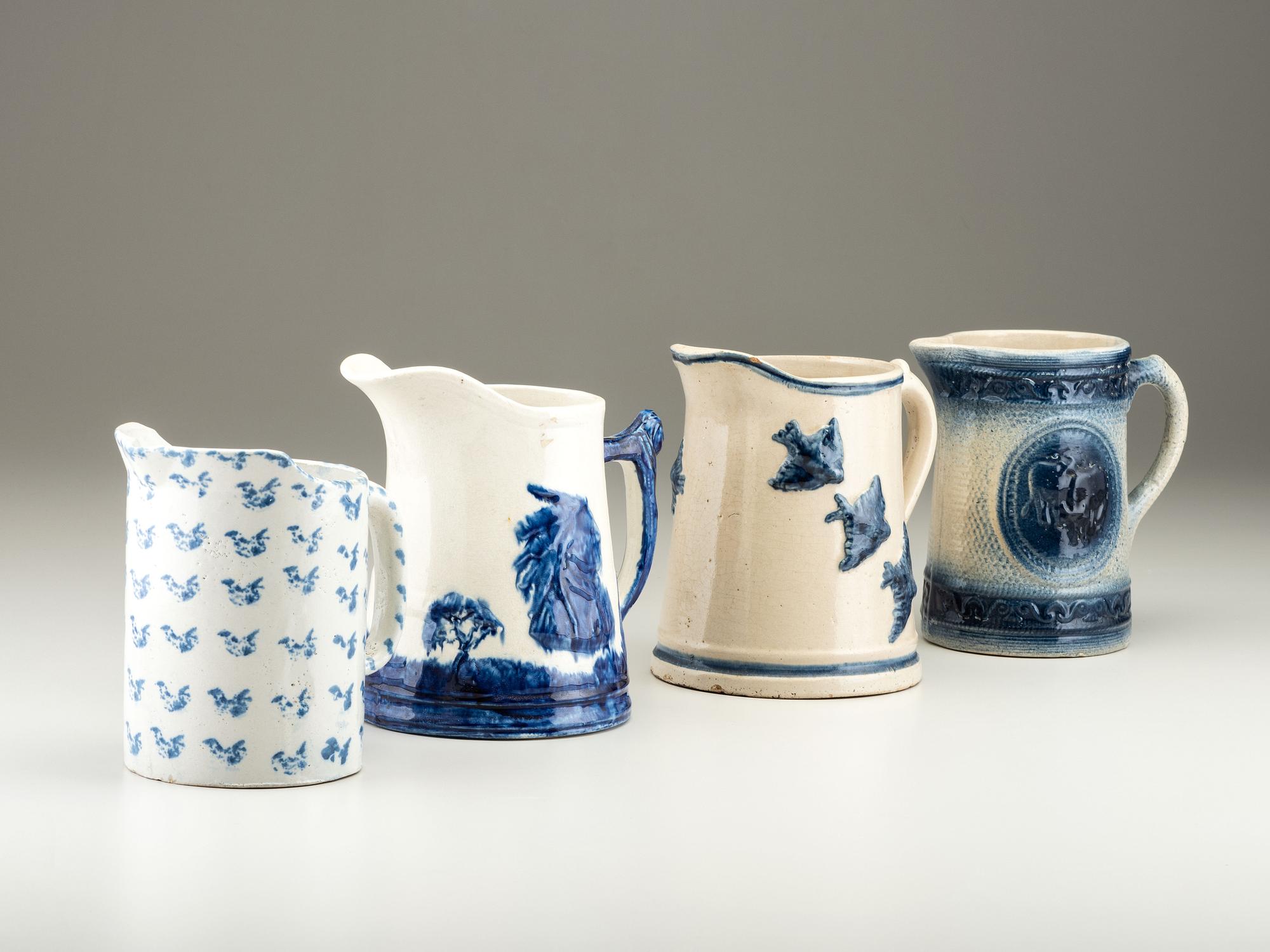 Four Cobalt Decorated Molded Stoneware Pitchers