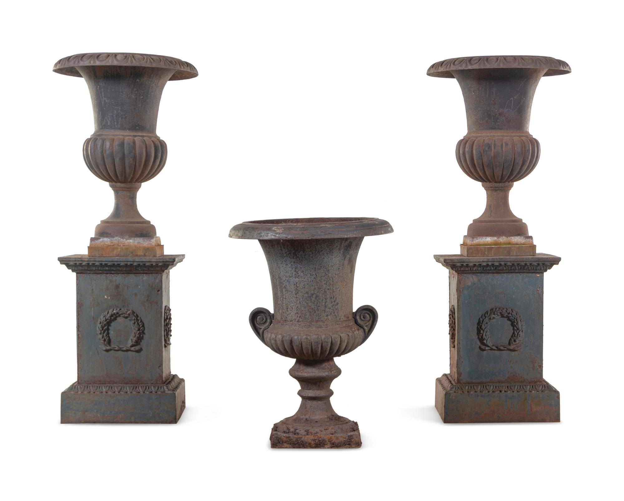 A Pair of Iron Garden Urns with Associated Plinths and Another Garden Urn