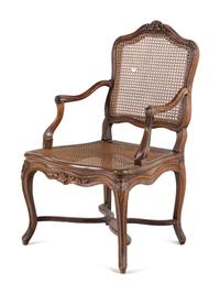 A Régence Carved Walnut and Caned Fauteuil