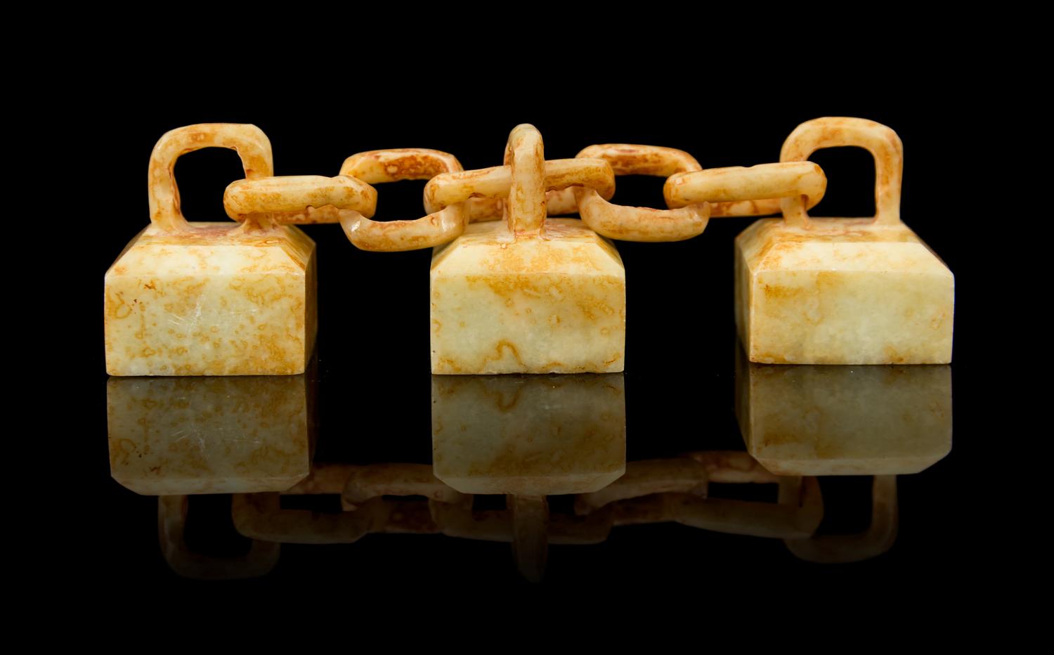 A Group of Three Celadon and Russet Jade Seals Length overall 4 inches.
