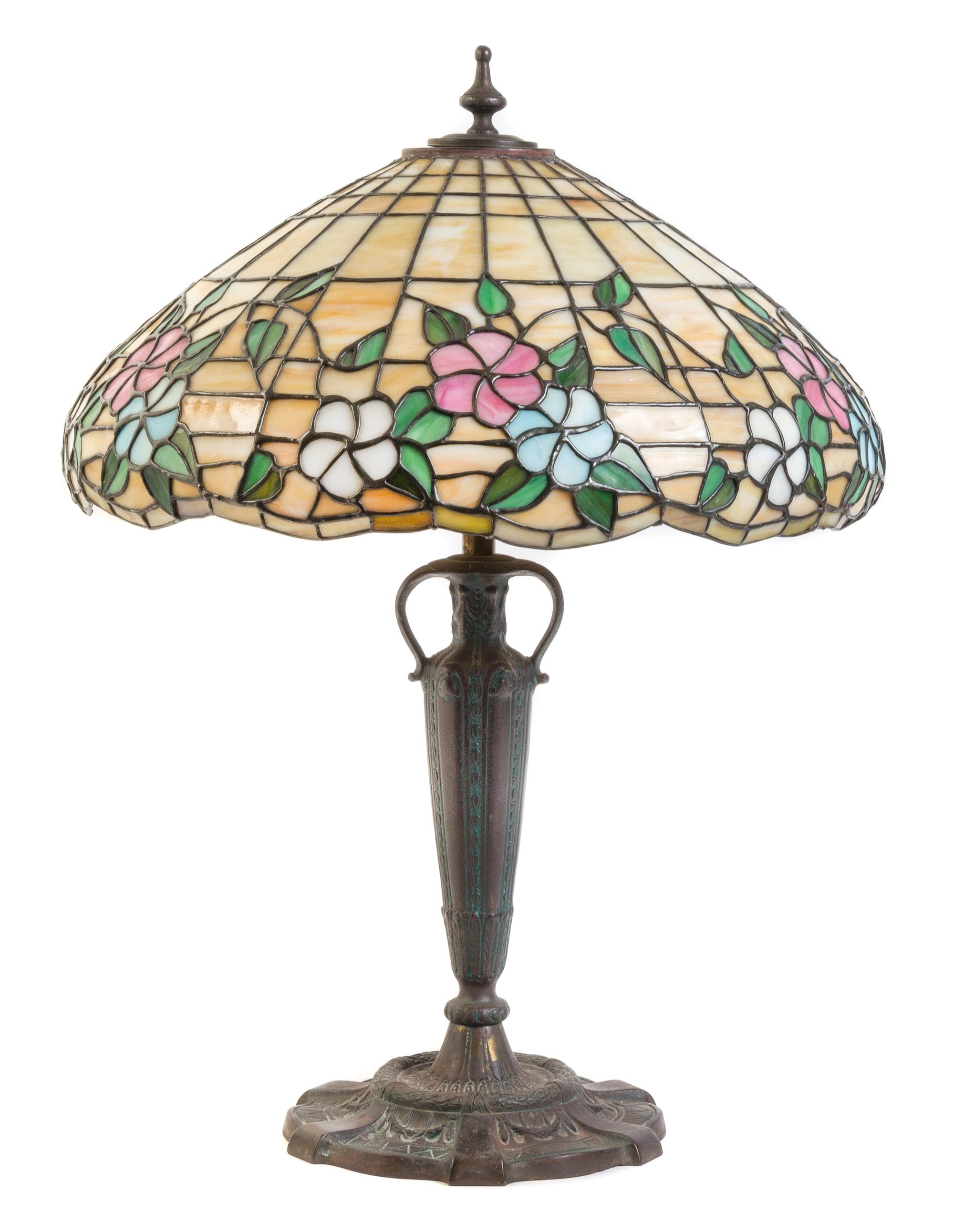 An American Leaded Glass and Bronze Lamp, THE MOSAIC SHADE COMPANY, CHICAGO, the shade having a floral pattern, raised on an vasiform s