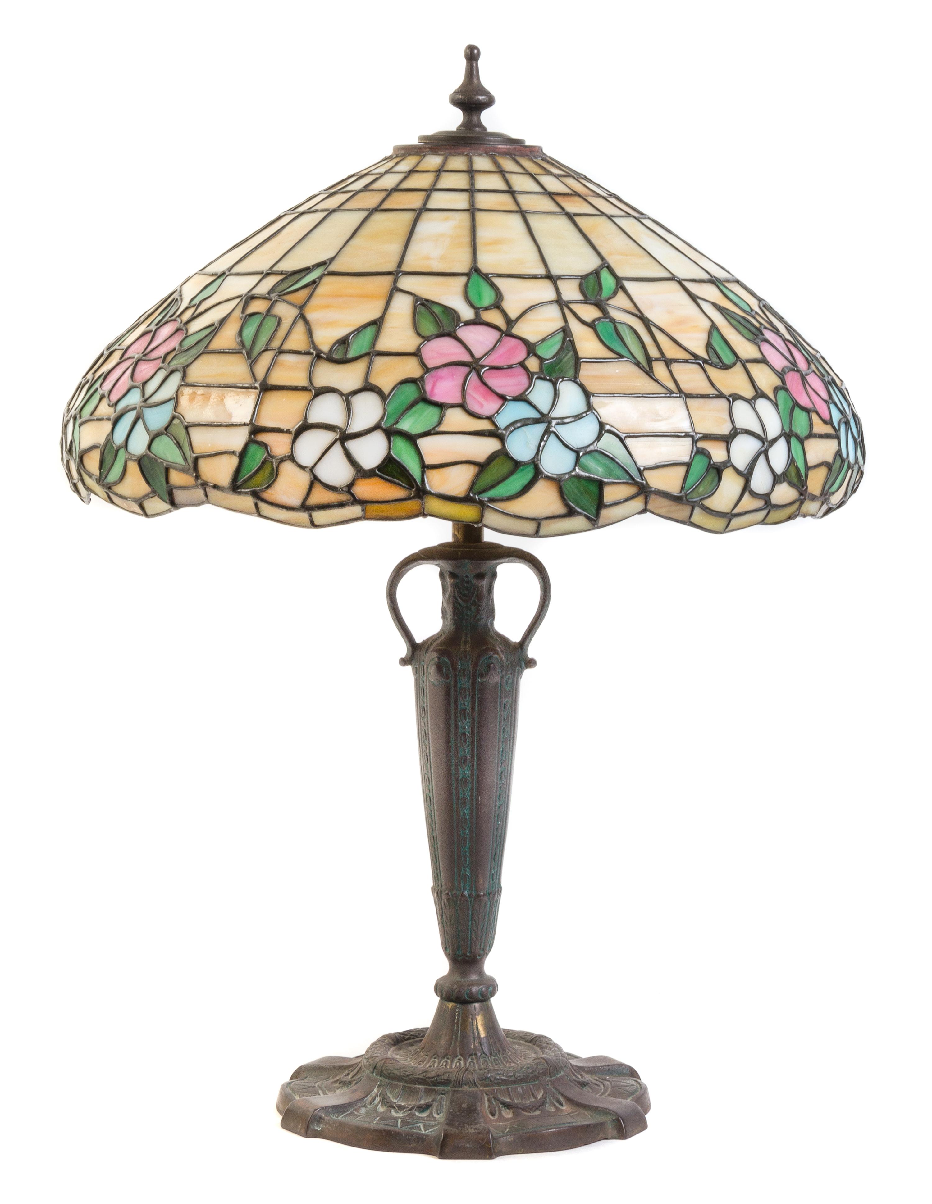 An American Leaded Glass and Bronze Lamp, THE MOSAIC SHADE COMPANY, CHICAGO, the shade having a floral pattern, raised on an vasiform s