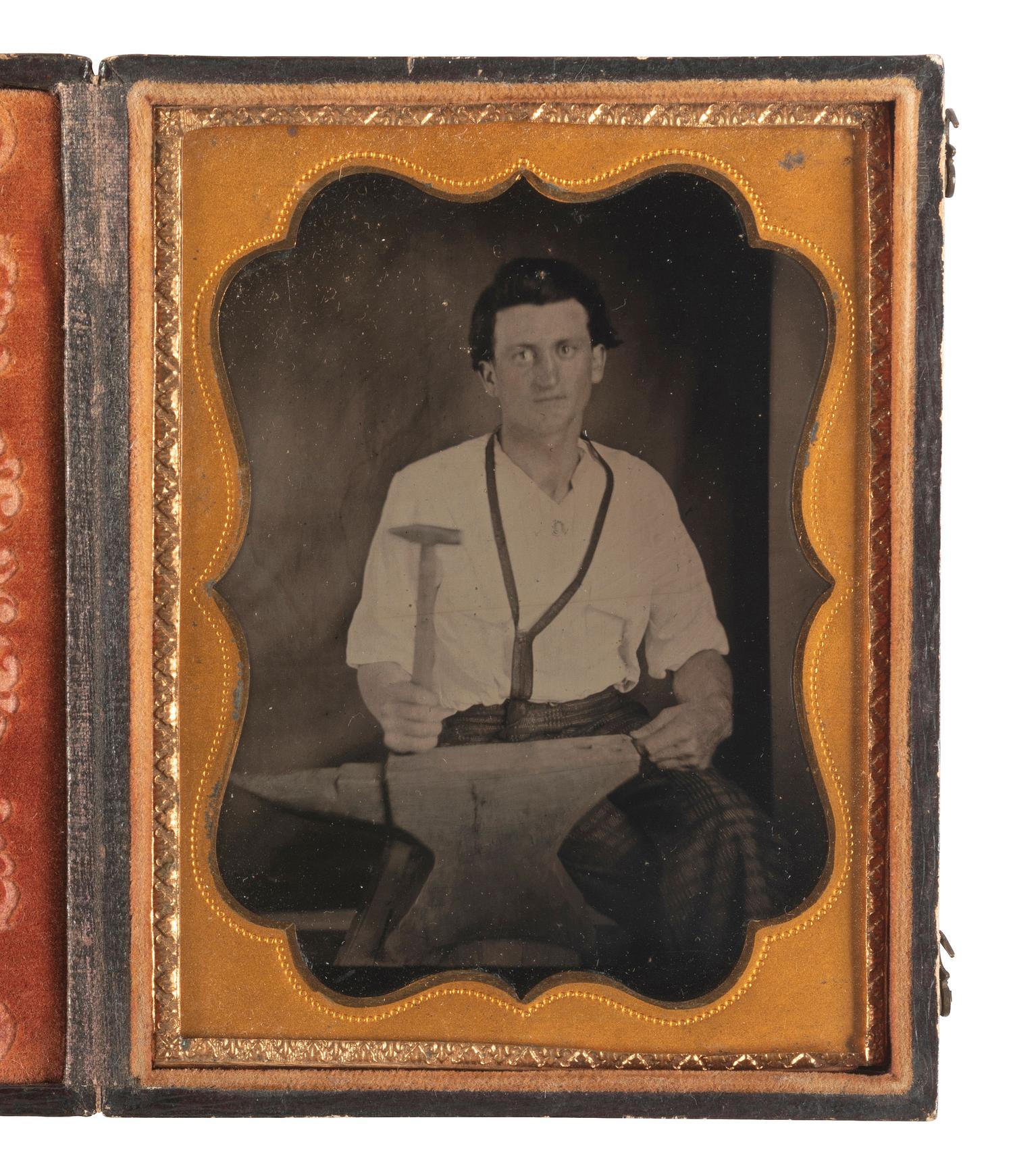 [EARLY PHOTOGRAPHY]. Quarter plate tintype of a blacksmith posed with a hammer and anvil.