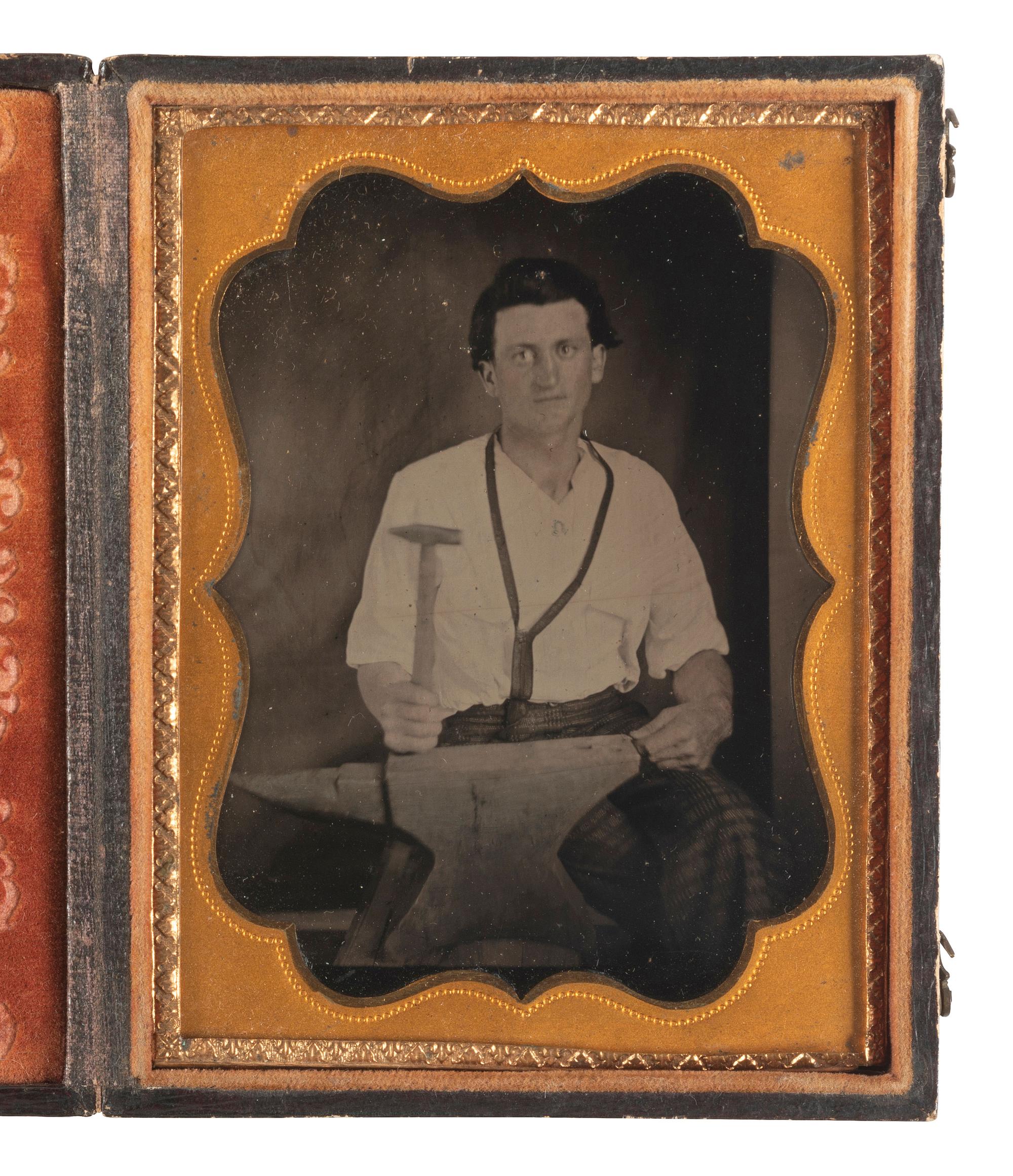 [EARLY PHOTOGRAPHY]. Quarter plate tintype of a blacksmith posed with a hammer and anvil.