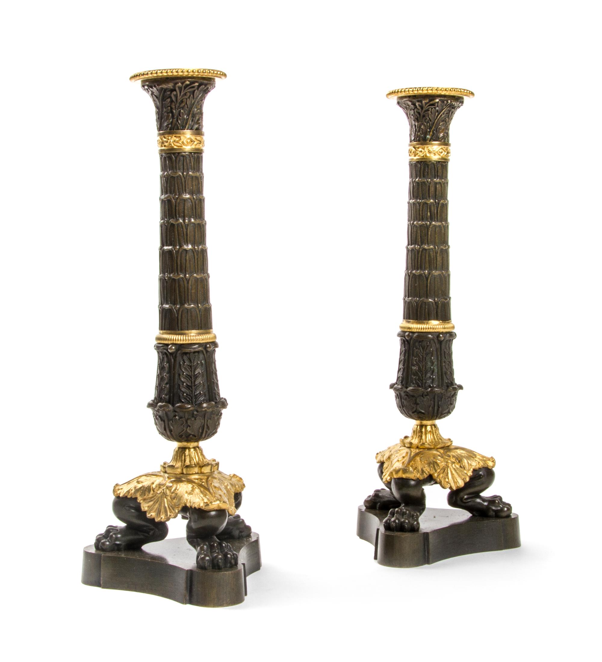 A Pair of Empire Patinated and Gilt Bronze Candlesticks, Height 11 inches.