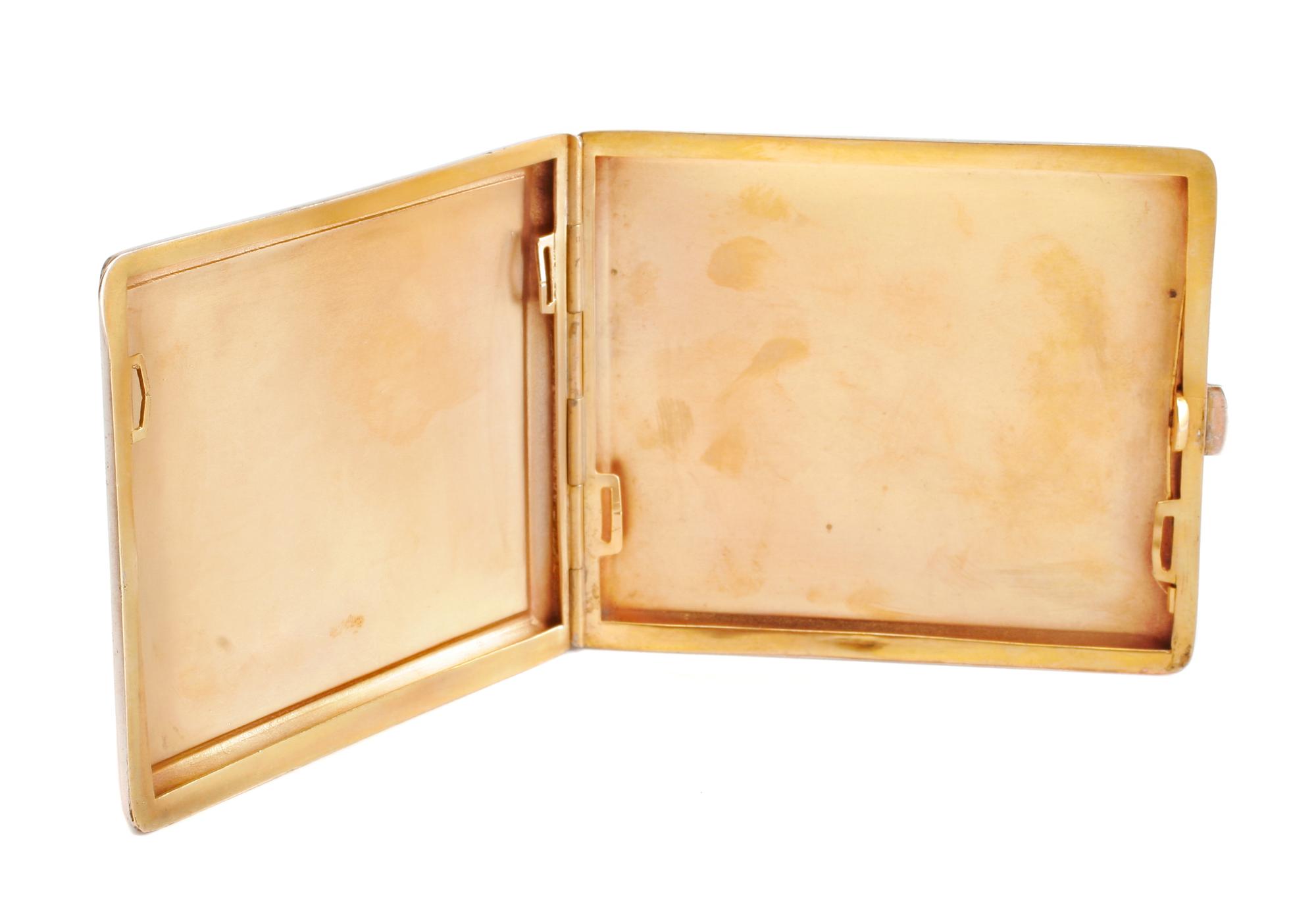 An Enameled Silvered Metal Cigarette Case, Early 20th Century, the lid enameled to show a seated nude playing two flutes in a garden se