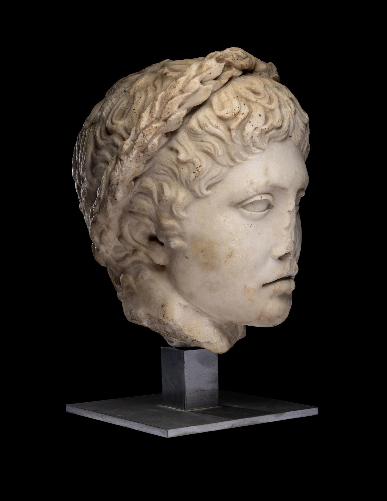 A Roman Marble Head of a Youth Wearing a Laurel Wreath