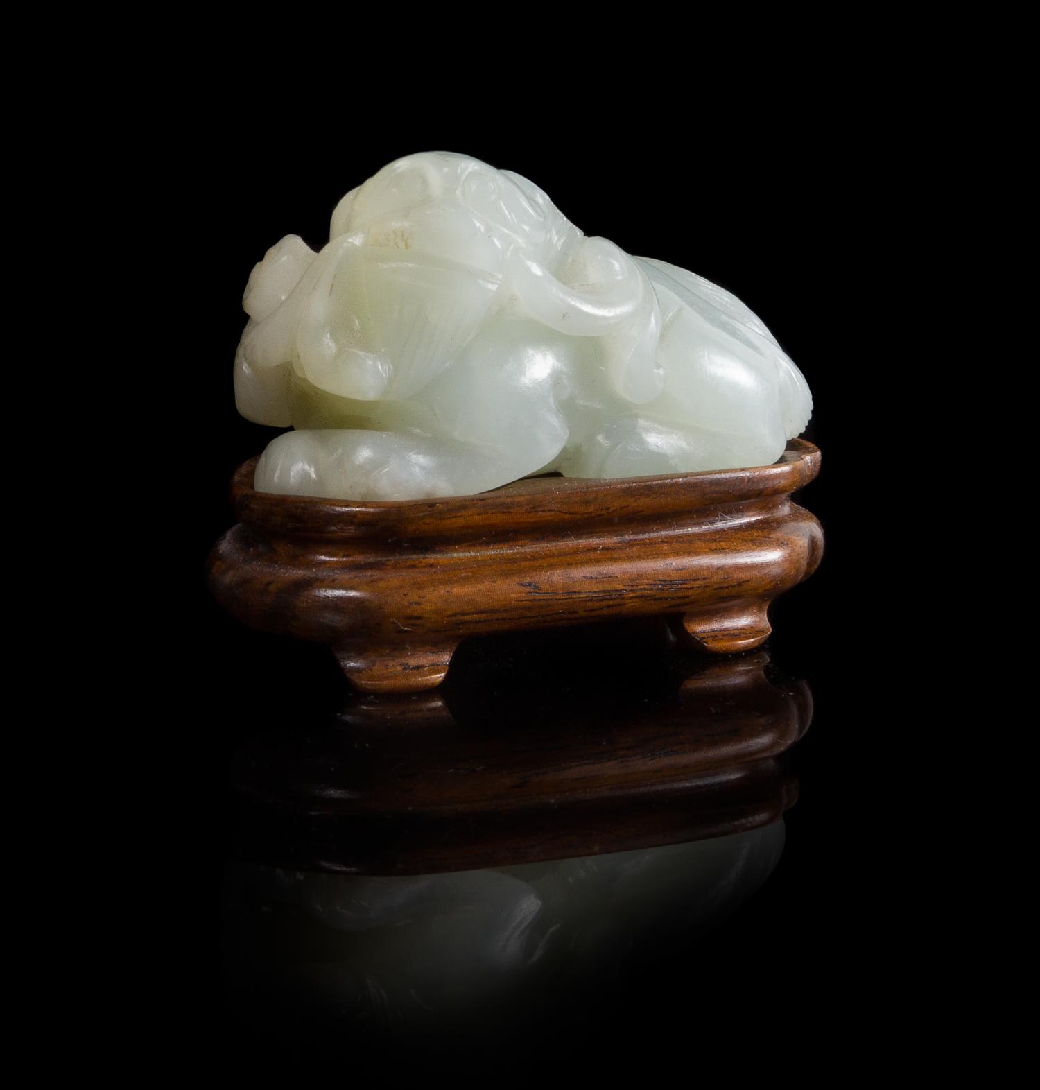 A White Jade Figure of a Recumbent Fu Lion Length 2 inches. — 18TH/19TH CENTURY