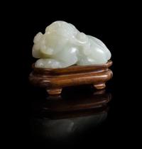 A White Jade Figure of a Recumbent Fu Lion Length 2 inches. — 18TH/19TH CENTURY