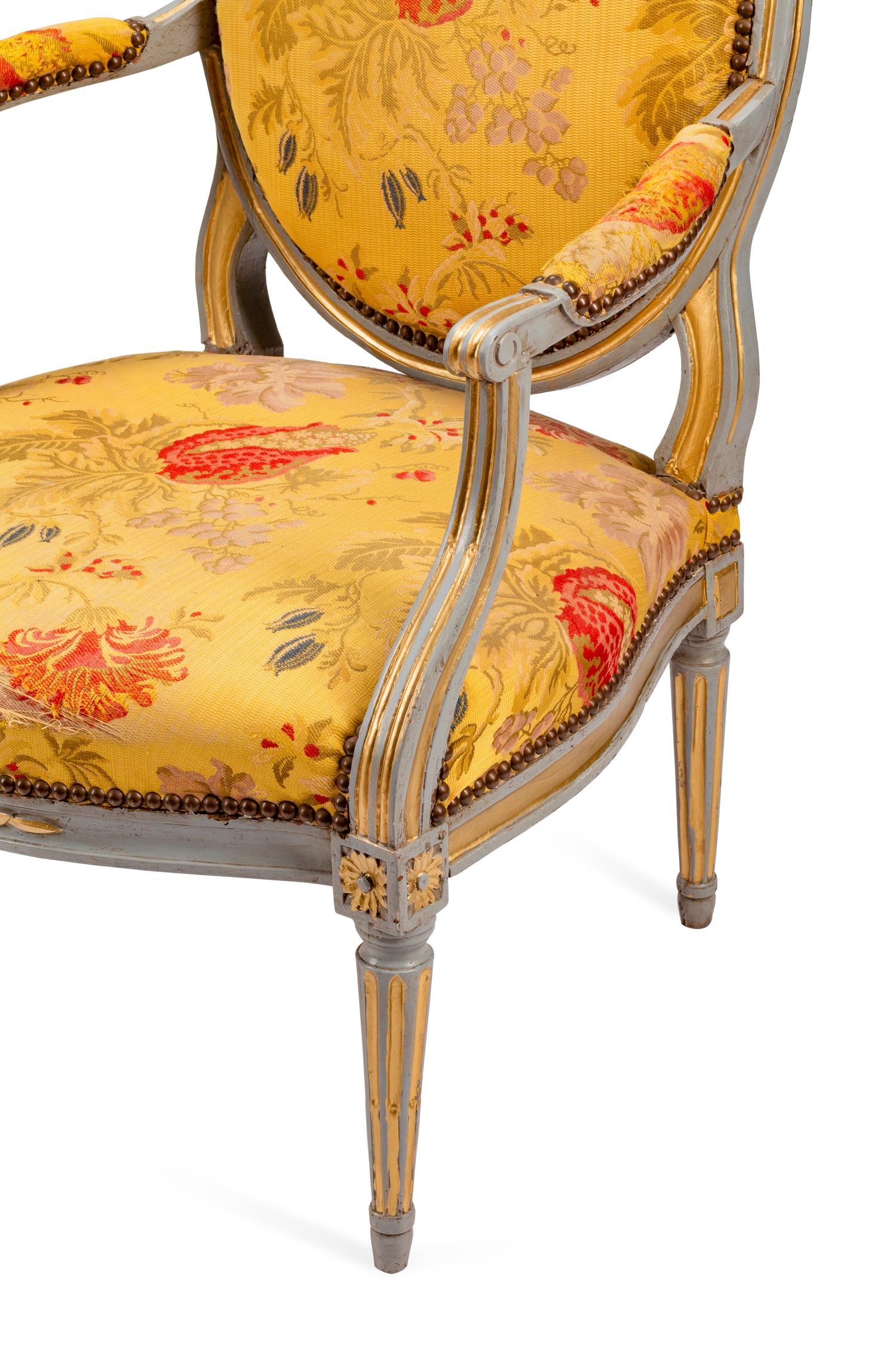 A Pair of Louis XVI Painted and Parcel Gilt Fauteuils