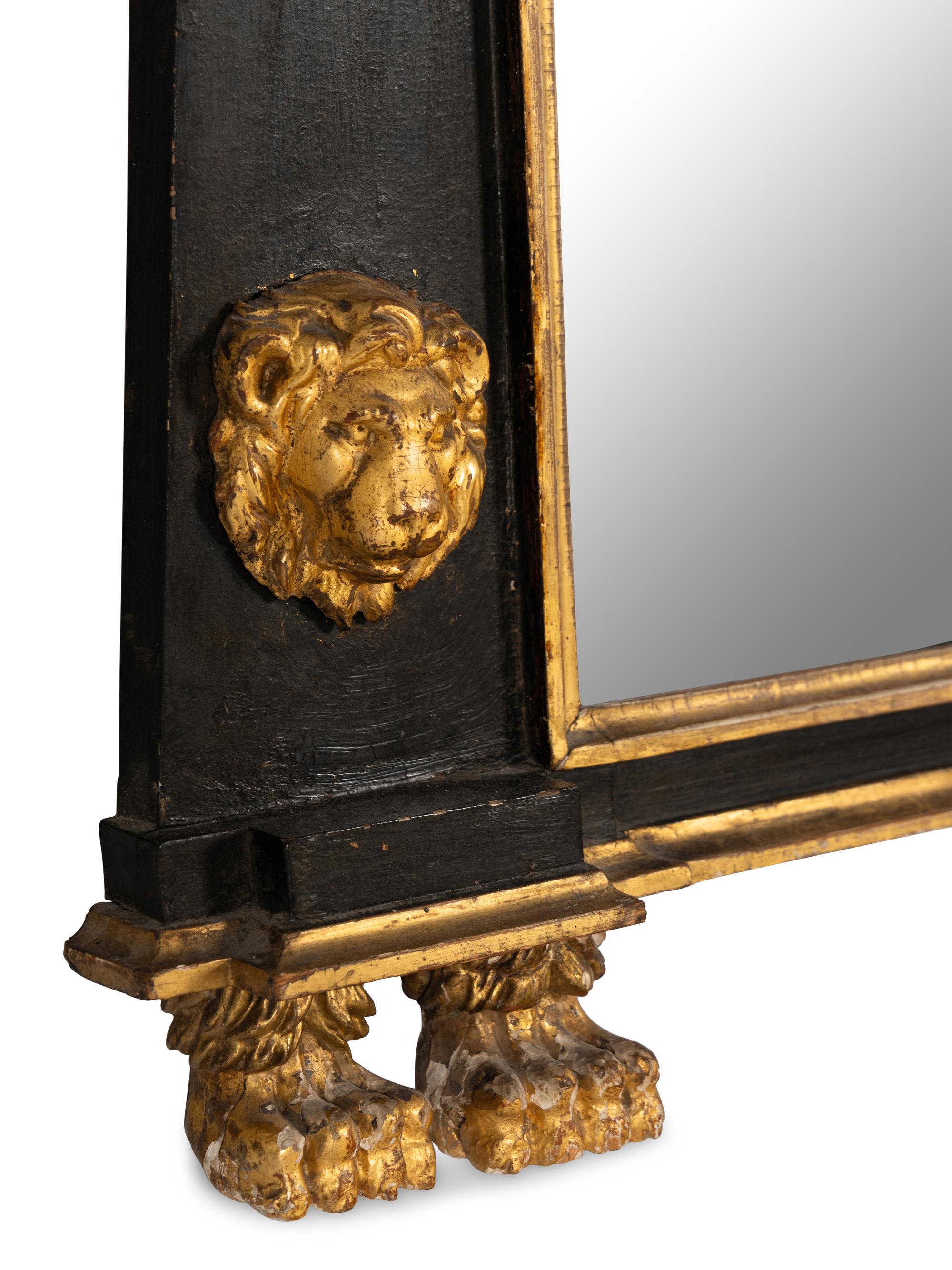 An Egyptian Revival Parcel Gilt and Ebonized Lion and Paw Decorated Over Mantel Mirror