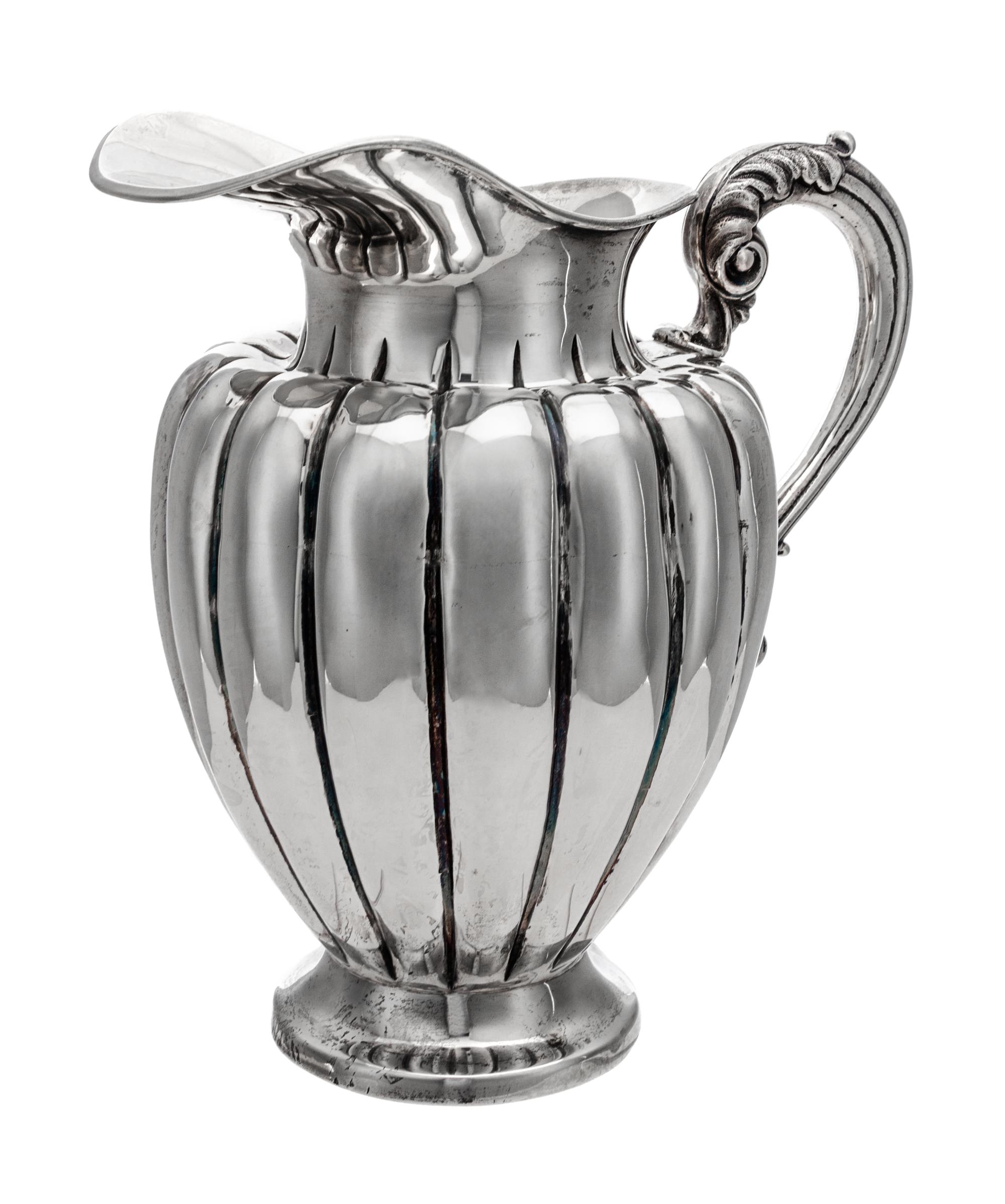 A South American Water Pitcher, Likely Peruvian, 20th Century, of baluster form, having an acanthus capped handle and a lobed body.