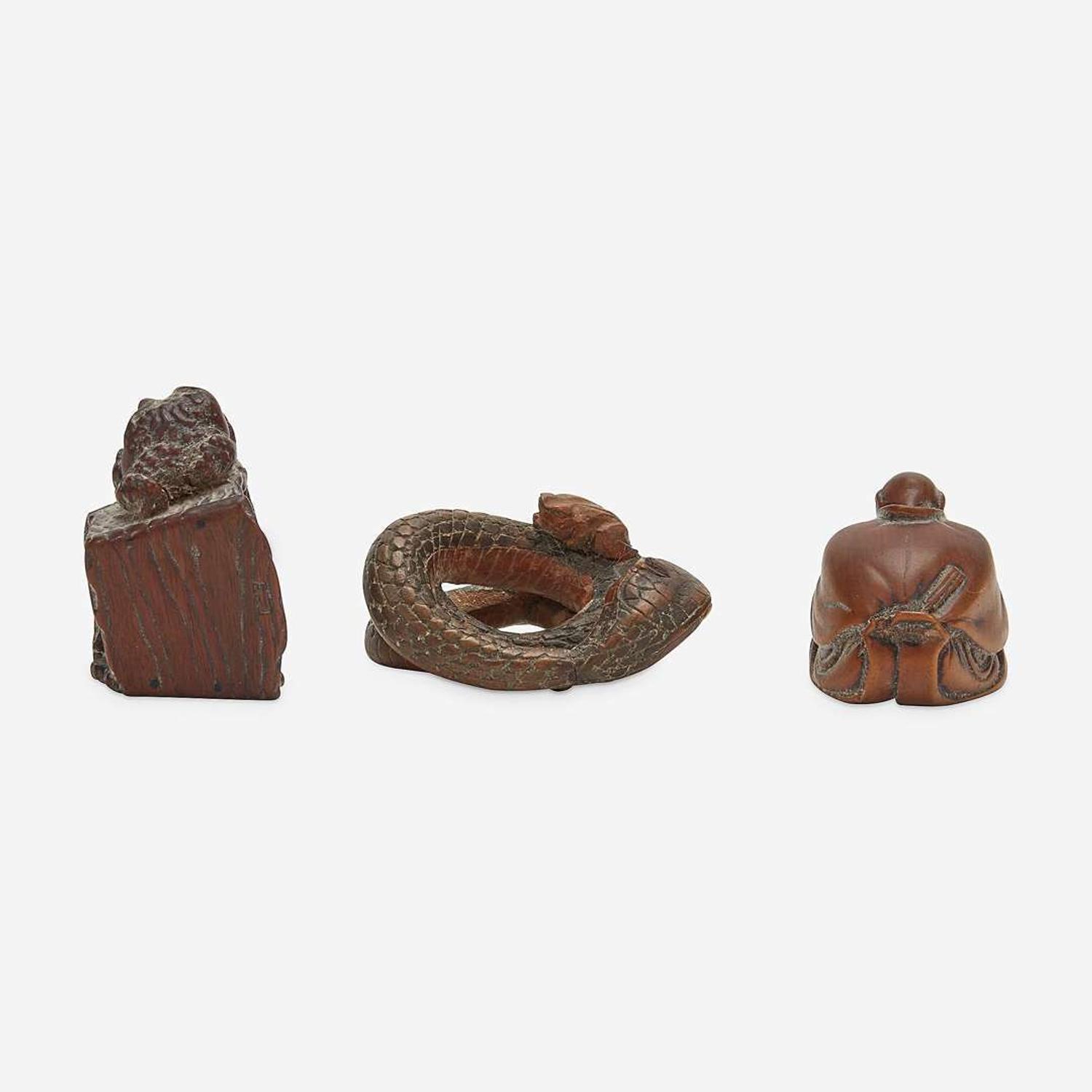 Three Japanese carved wood netsuke: measure and toad, snake and toad, monk and jar