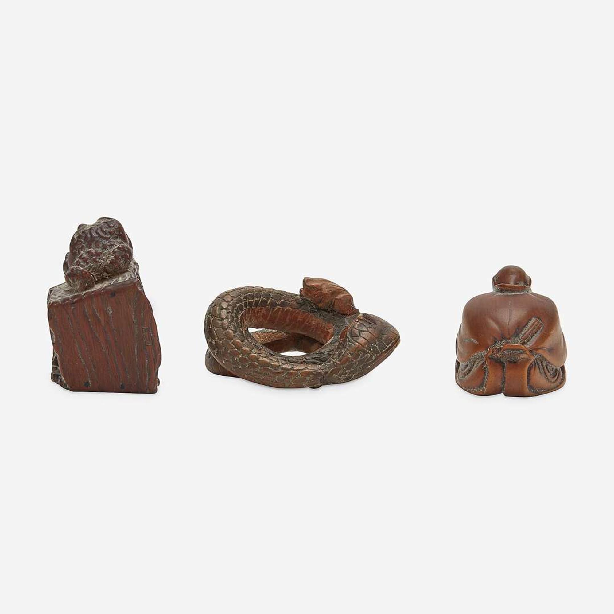 Three Japanese carved wood netsuke: measure and toad, snake and toad, monk and jar