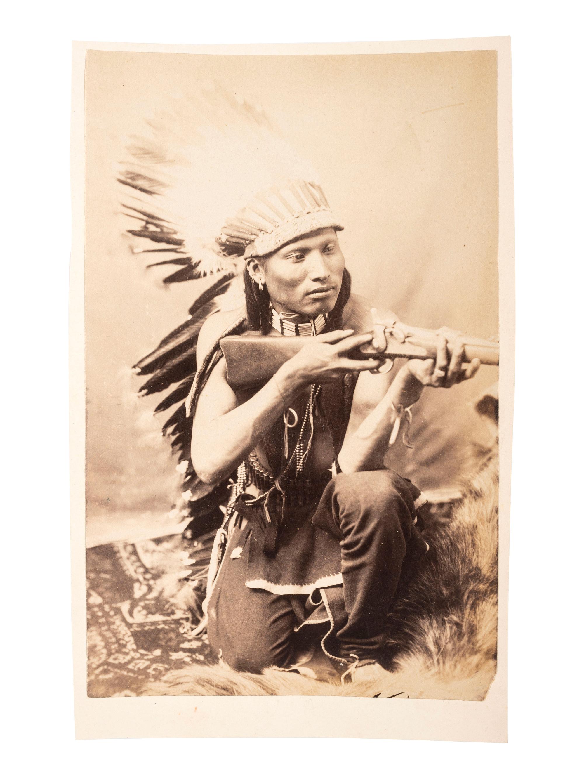 [NATIVE AMERICANS]. [BAKER & JOHNSTON, photographers]. Cabinet card of an Arapaho kneeling with rifle. [Evanston, Wyoming: ca 1890s].