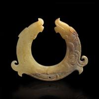 A finely carved Chinese beige and brown jade circular pendant 玉佩一件